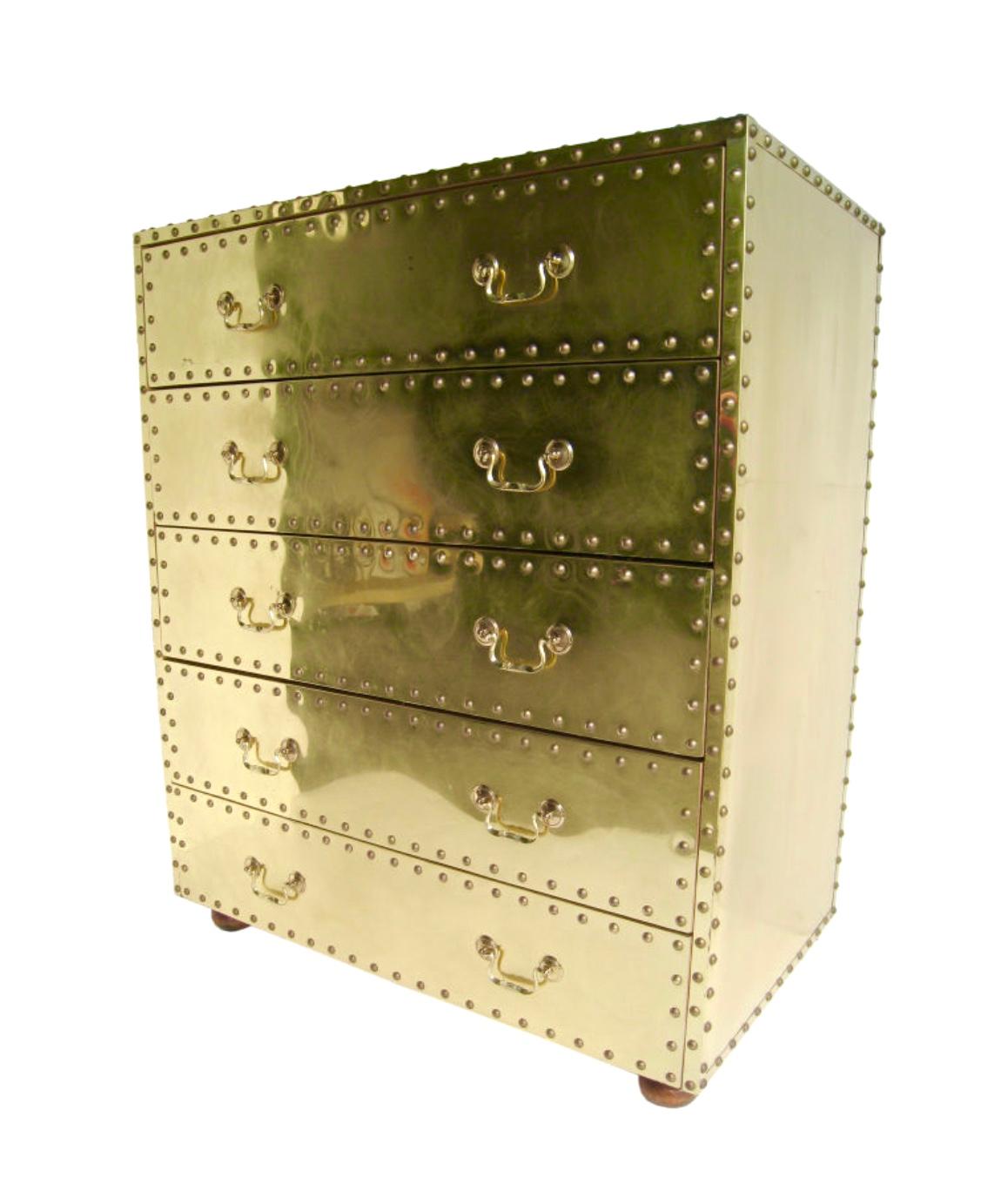 Glamorous vintage brass dresser made in Spain by Spanish Design House, Sarreid Ltd. Made of wood and clad in brass with nailhead trim. This dresser has five large drawers and rests on four bun feet made of wood. There are no deep scratches or dents.