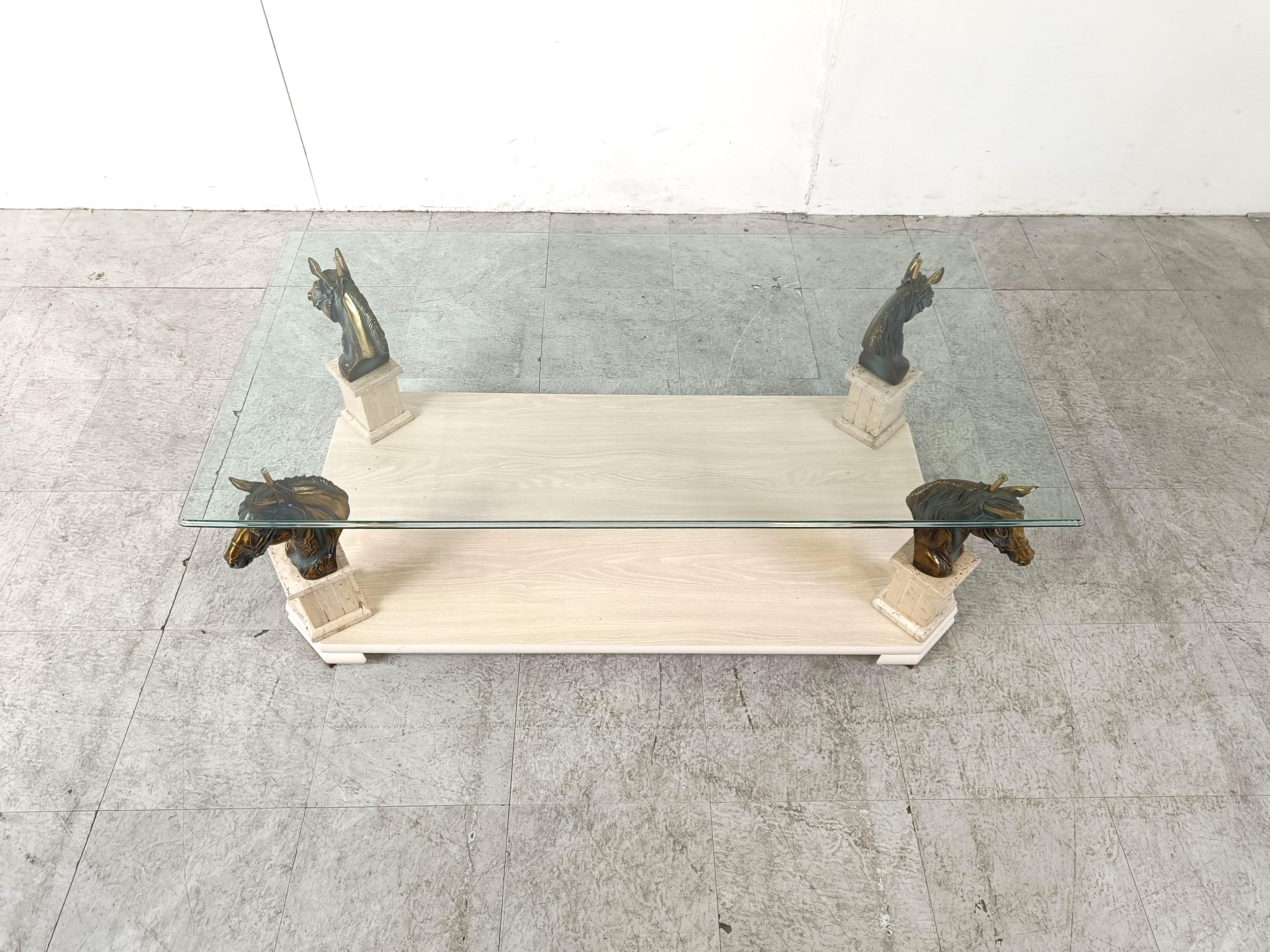 Vintage brass horse head coffee table with a clear glass table top and a travertine and wooden base.

Beautiful eye catching coffee table.

In the style of Maison Jansen

Made in Belgium in the 1970s 

Good condition

Height: 46cm/18.11