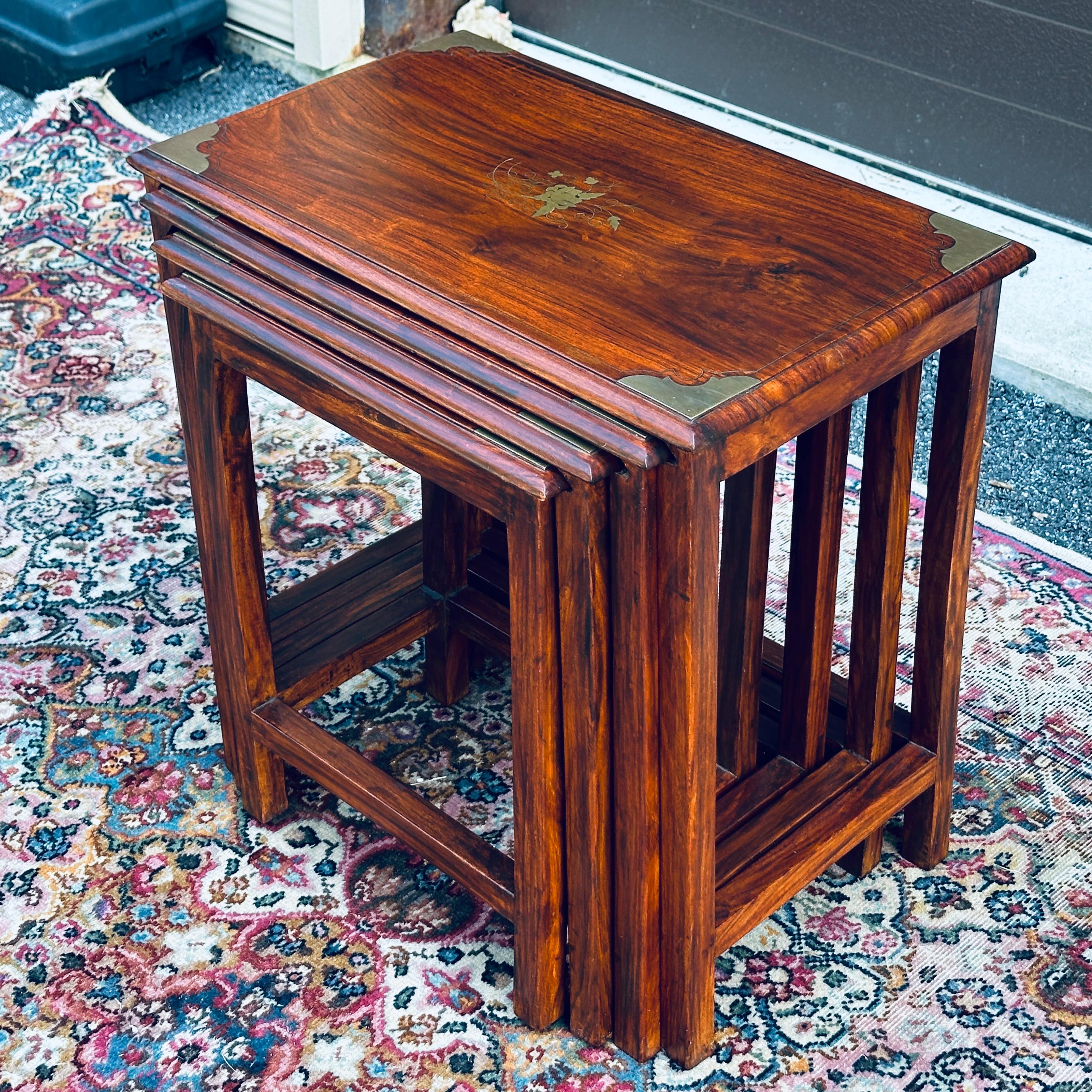 Vintage nest of four solid rosewood tables featuring brass marquetry and corner detail.

The individual tables measure approximately:

21” wide x 12.75” deep x 21.1” tall
18.75” wide x 11.75” deep x20.5” tall
16.25” wide x 10.75” deep x19.5”