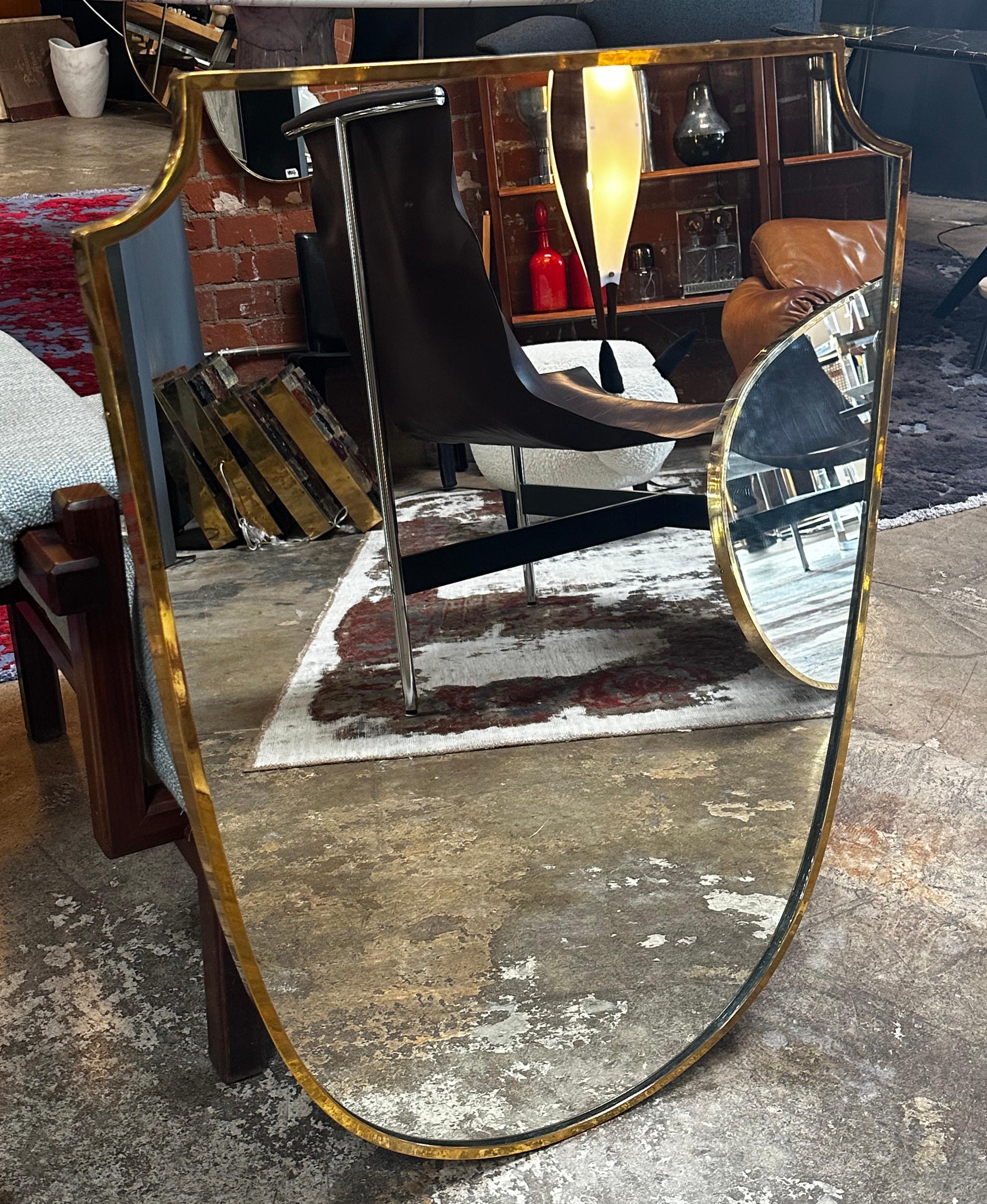Vintage Italian Sculptural wall mirror made in Italy with a brass frame and unique shape.