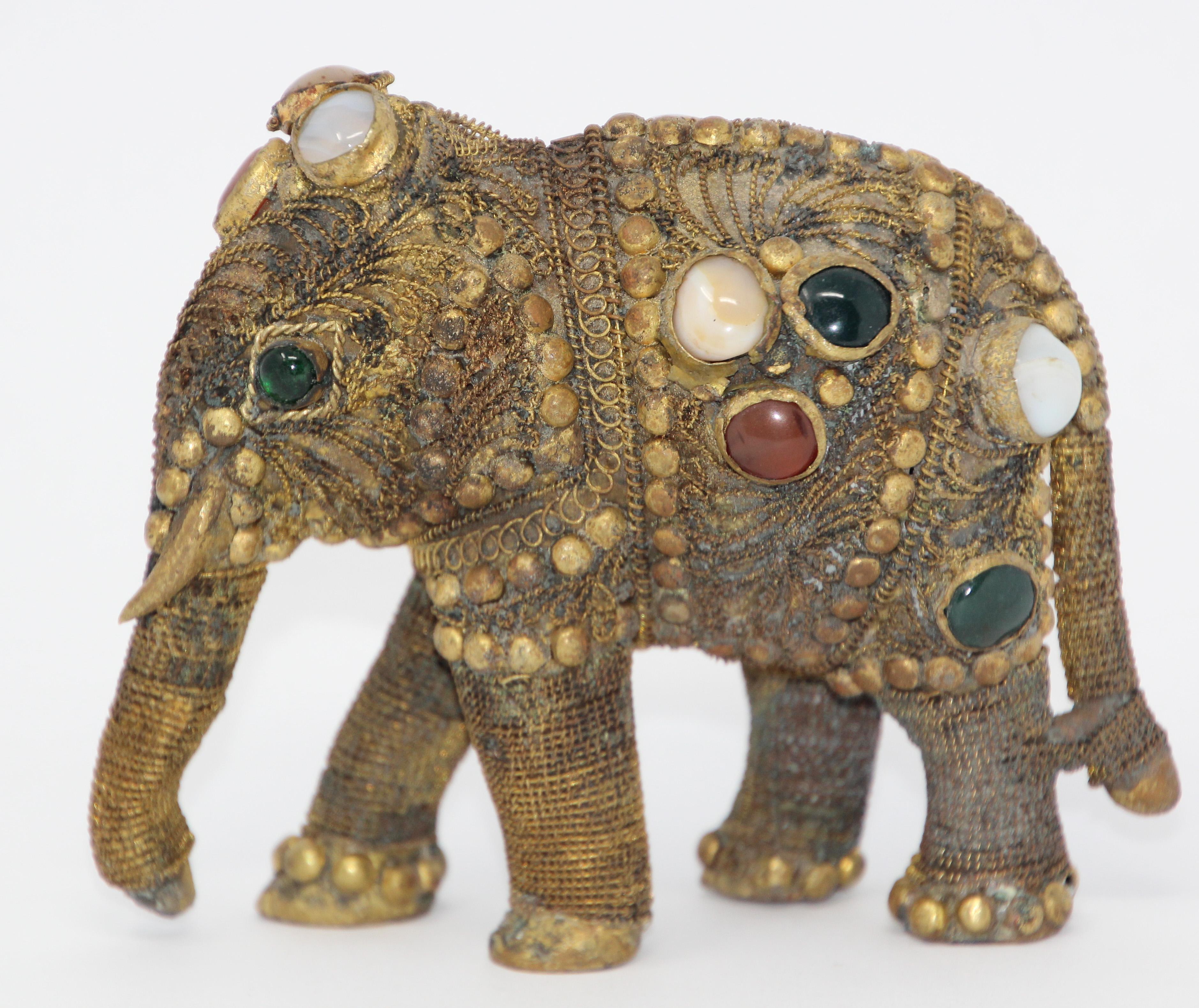 Vintage brass jeweled elephant sculpture paper weight.
Vintage solid brass elephant sculpture with semi precious gem stones and filigree adornment and filigree work. 
Rare decorative brass filigree elephant with intricate design heavily inlaid