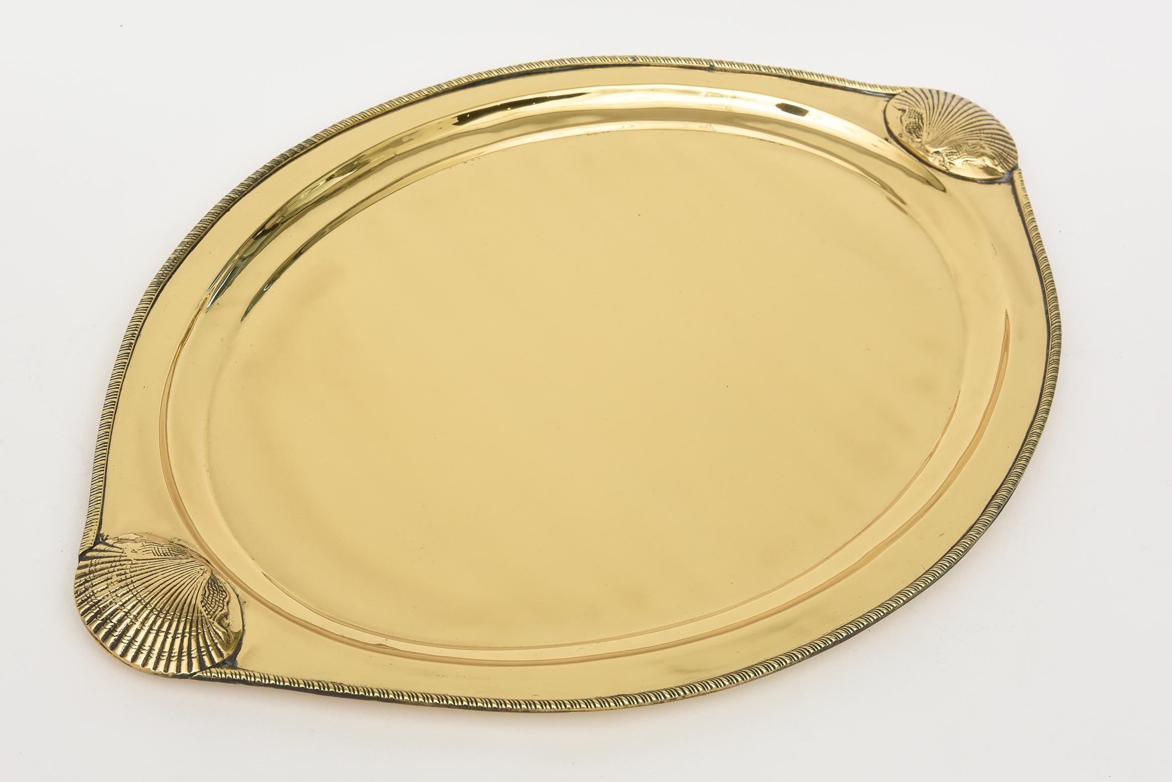 This vintage lovely brass oval tray has embellishments of shell design at either end along with a spiral braided perimeter. It is from the 70's and a great size. it was polished and then lacquered so it will not tarnish. Great barware and for your