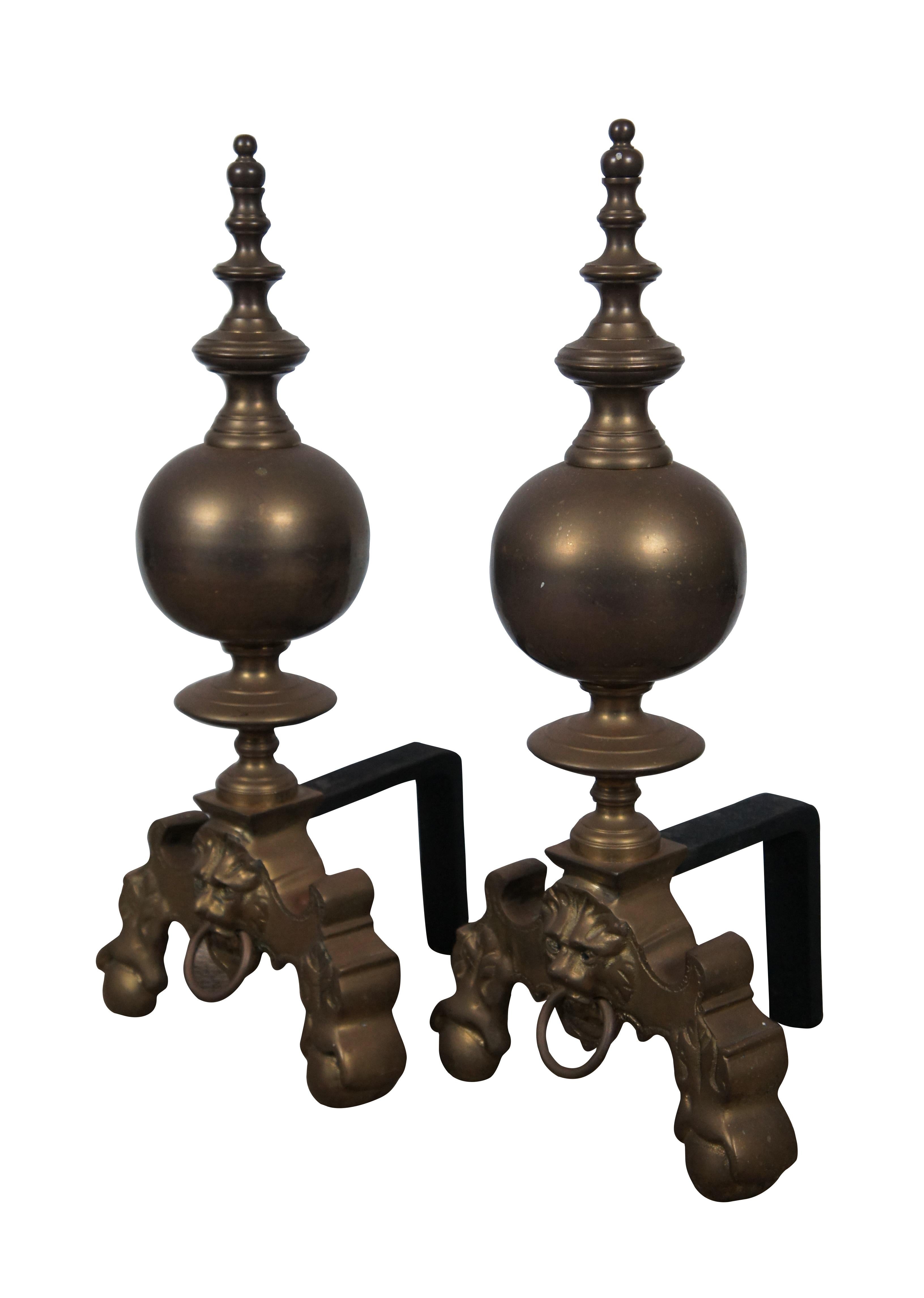 Vintage circa 1970's iron and brass firedogs / andirons featuring simplified ball and claw feet, lion's head with ring in it's mouth on the base, supporting a substantial cannonball baluster with turned finial.

Dimensions:
9.5