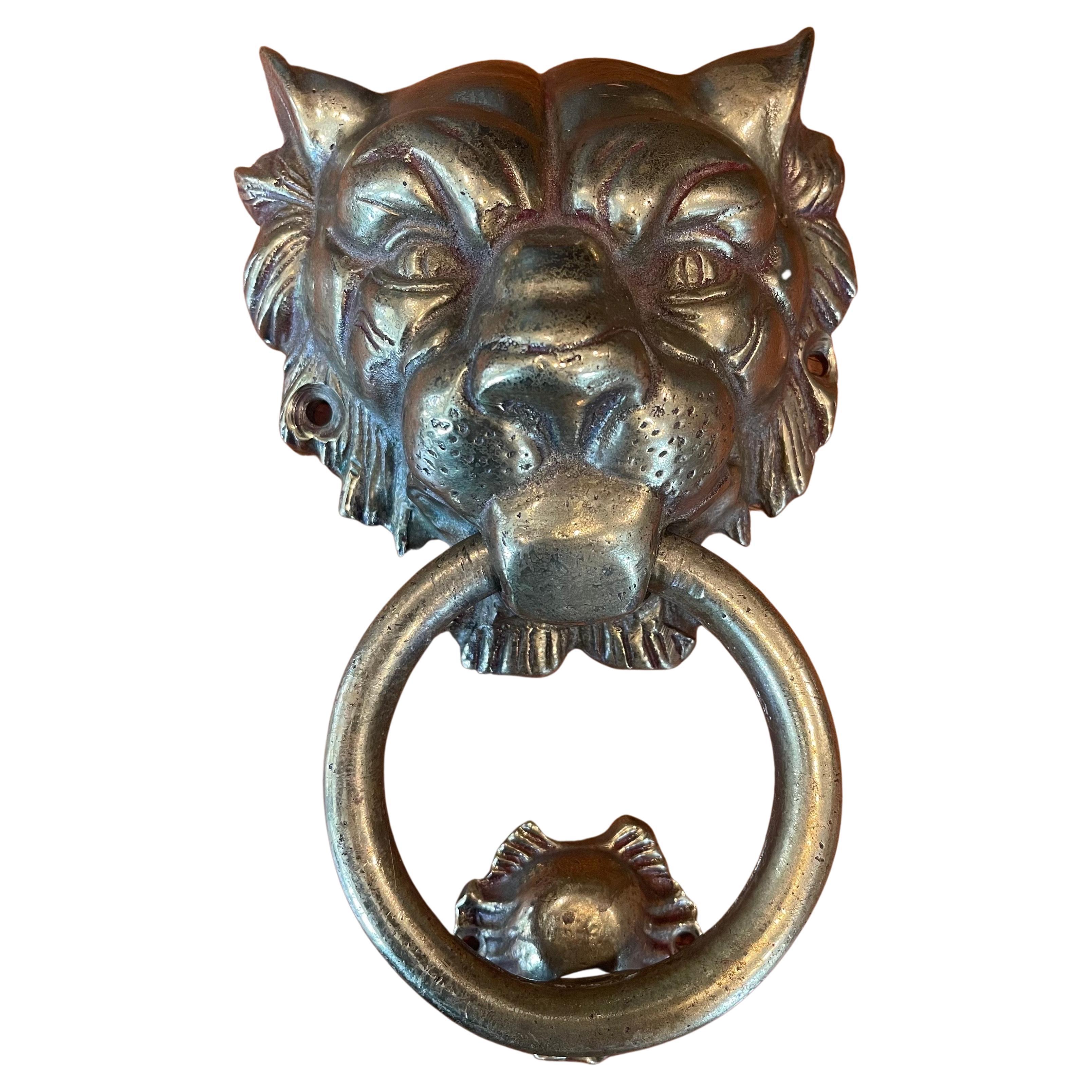 Well worn vintage brass lion head door knocker, circa 1970s. The piece is made of cast brass and is quite heavy. The knocker is in very good vintage condition and measures 6