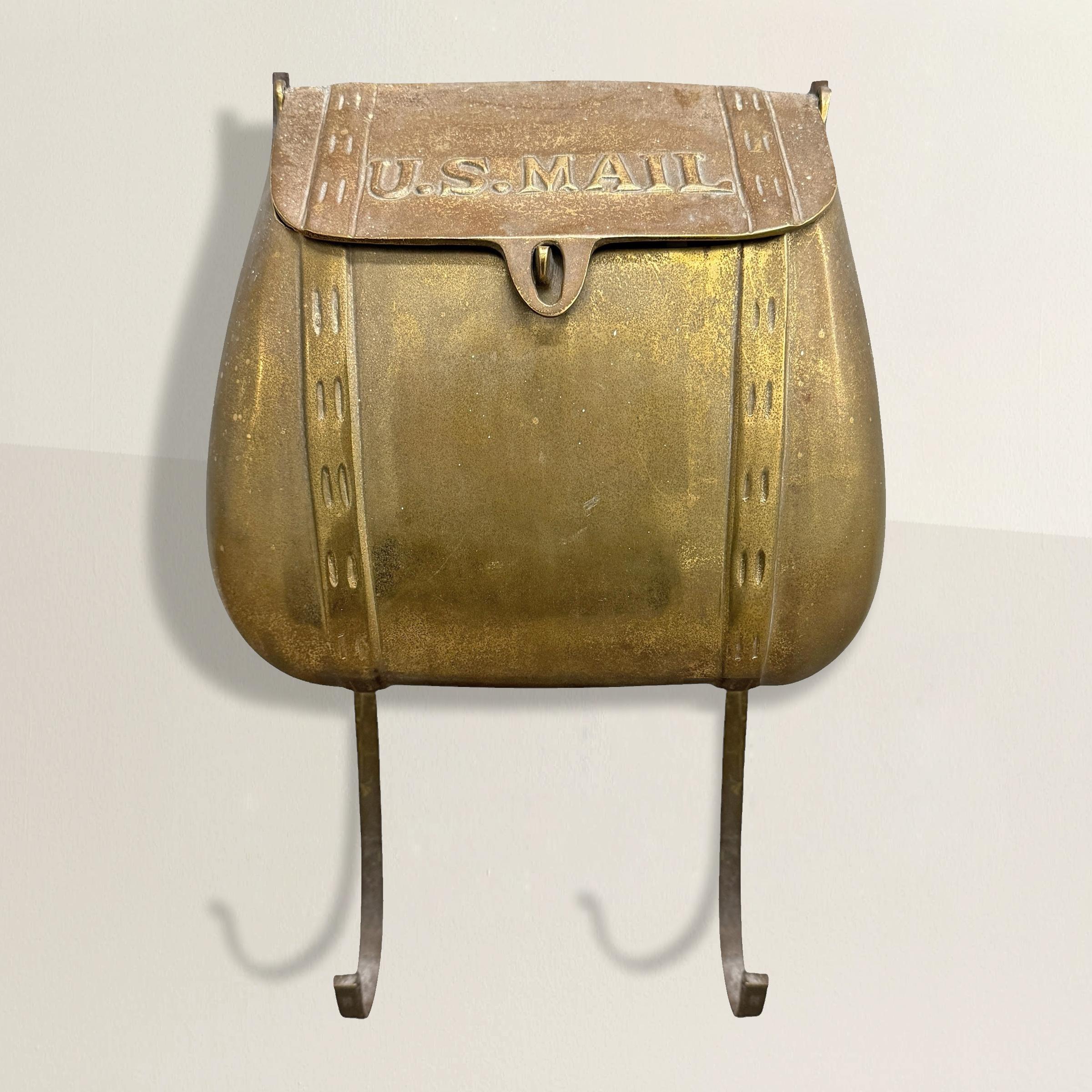 A charming mid-20th century American cast brass mailbox, cleverly designed in the form of a classic mailbag. The sculptural details are remarkable—the bag appears full and even features faux-stitched seams that mimic a leather bag. The flip-top lid