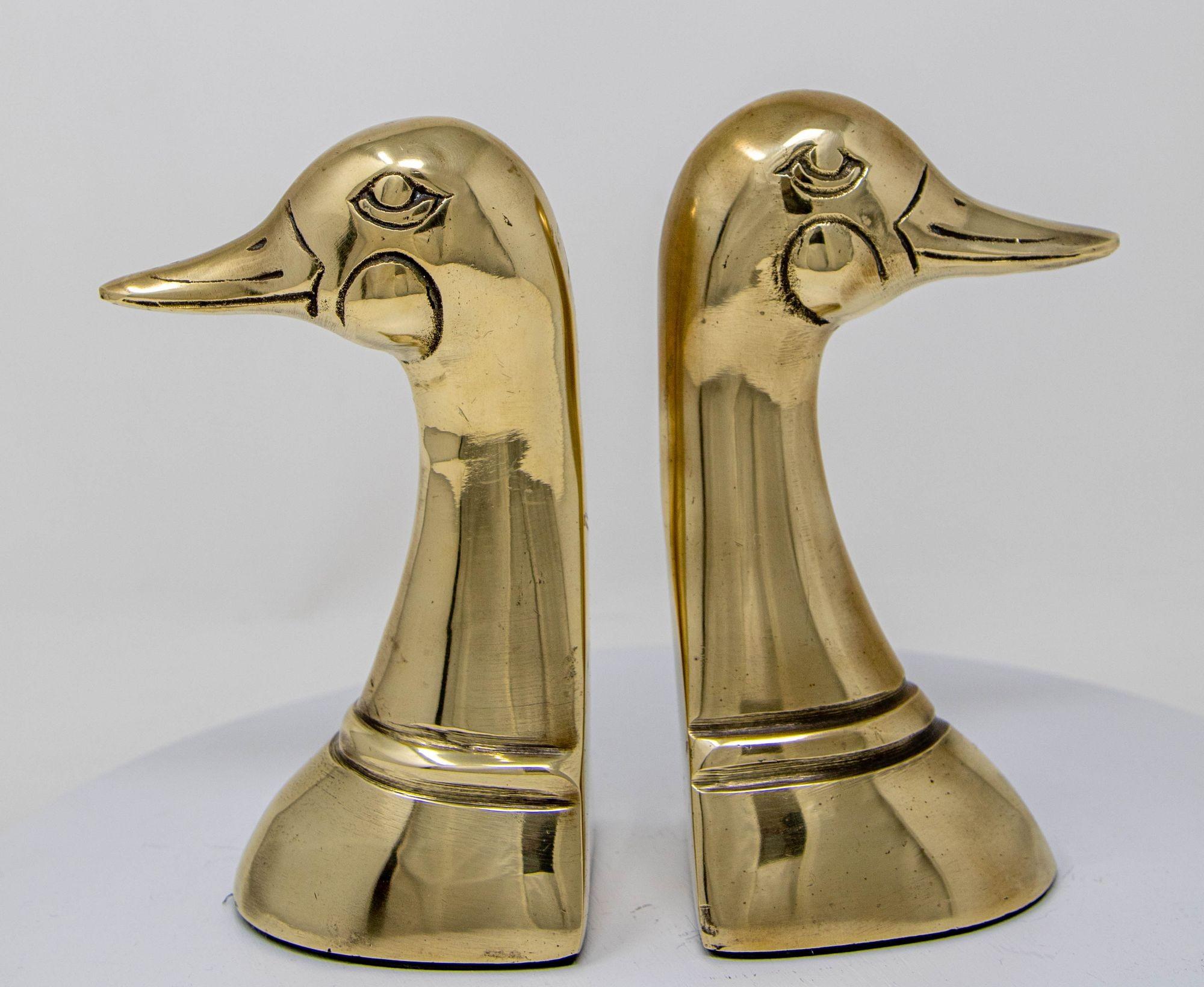 Fermalibri in ottone lucido a forma di anatra Sarreid Ltd. Stile anni '50 Una coppia.
Coppia vintage di fermalibri a testa d'anatra in ottone massiccio fuso e lucidato.
Coppia di reggilibri decorativi in ottone lucido della metà del secolo scorso