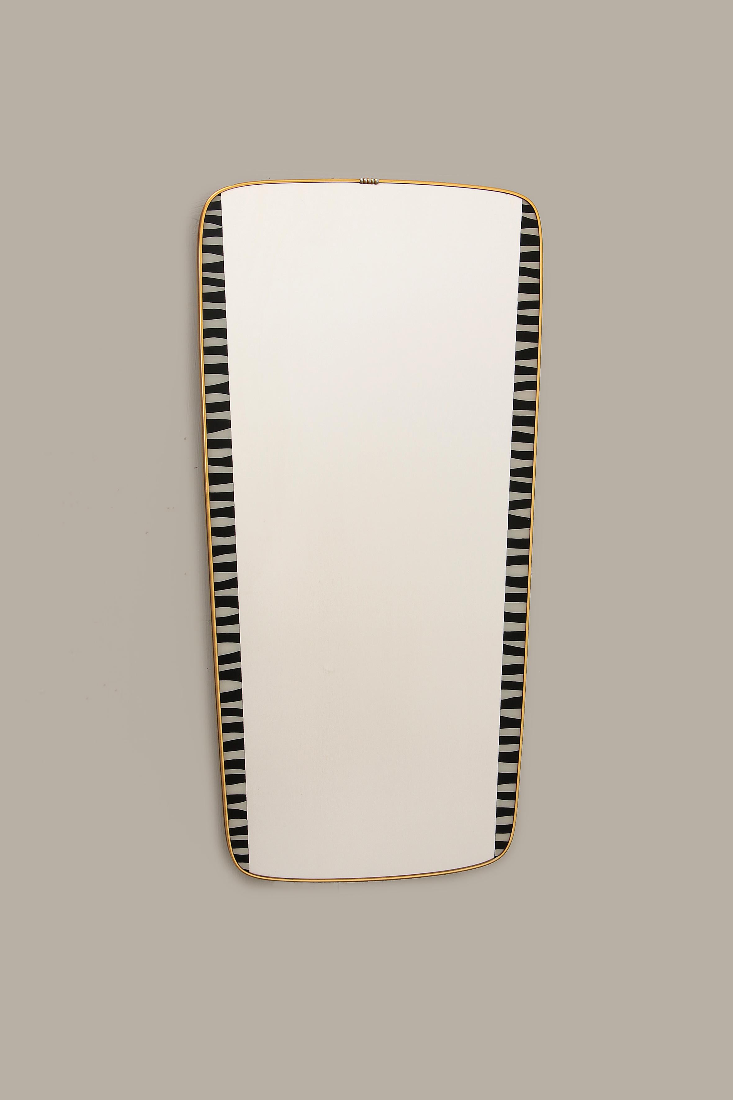 A beautiful vintage brass mirror. The mirror is from the 1960s and was made in Germany.

The mirror has a black asymmetrical edge with beautiful golden details. This mirror has a subtle design, but its retro look makes it a special addition to any