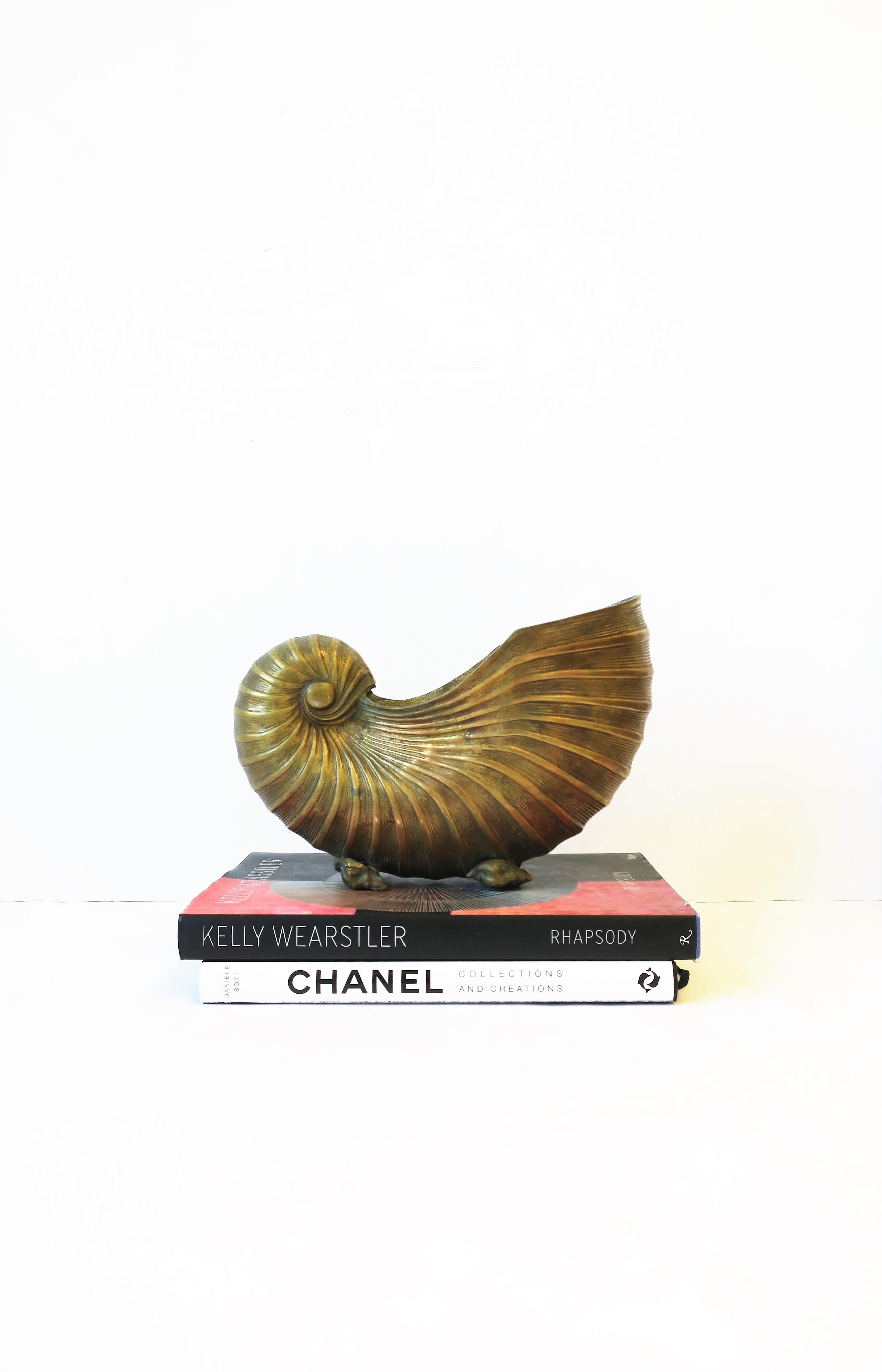 A substantial vintage brass nautilus seashell flower or plant pot holder cachepot jardinière, circa 20th century. Piece has beautiful details including brass conch sea shell feet. This piece maintains its beautiful patina as shown in images.