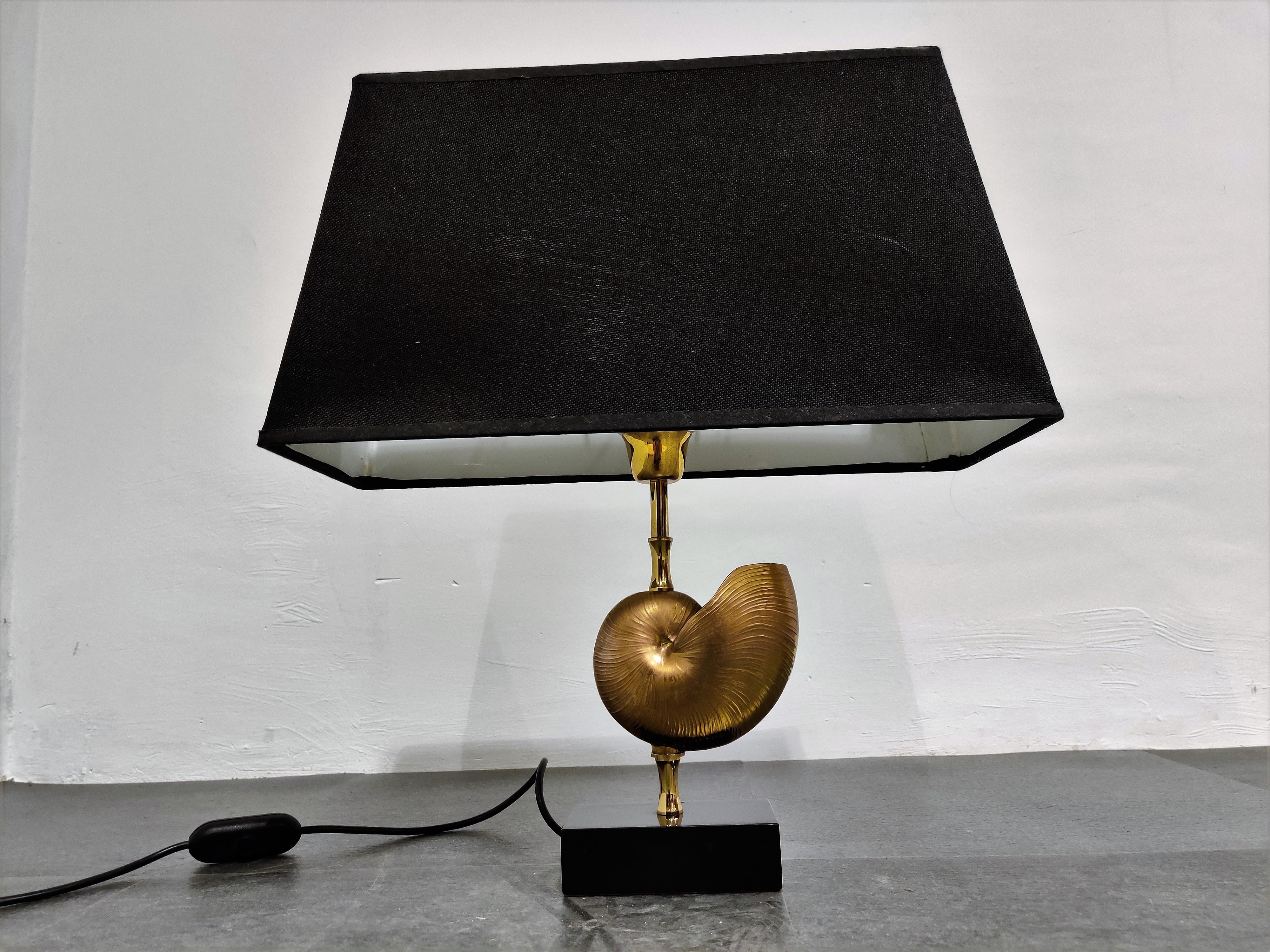 Beautiful brass nautilus shell table lamp in the style of Maison Charles.

This luxurious lamp has a golden nautilus shell center piece.

Good condition.

The lamp works with one standard E27 light bulb and is tested for safe use.

1970s,