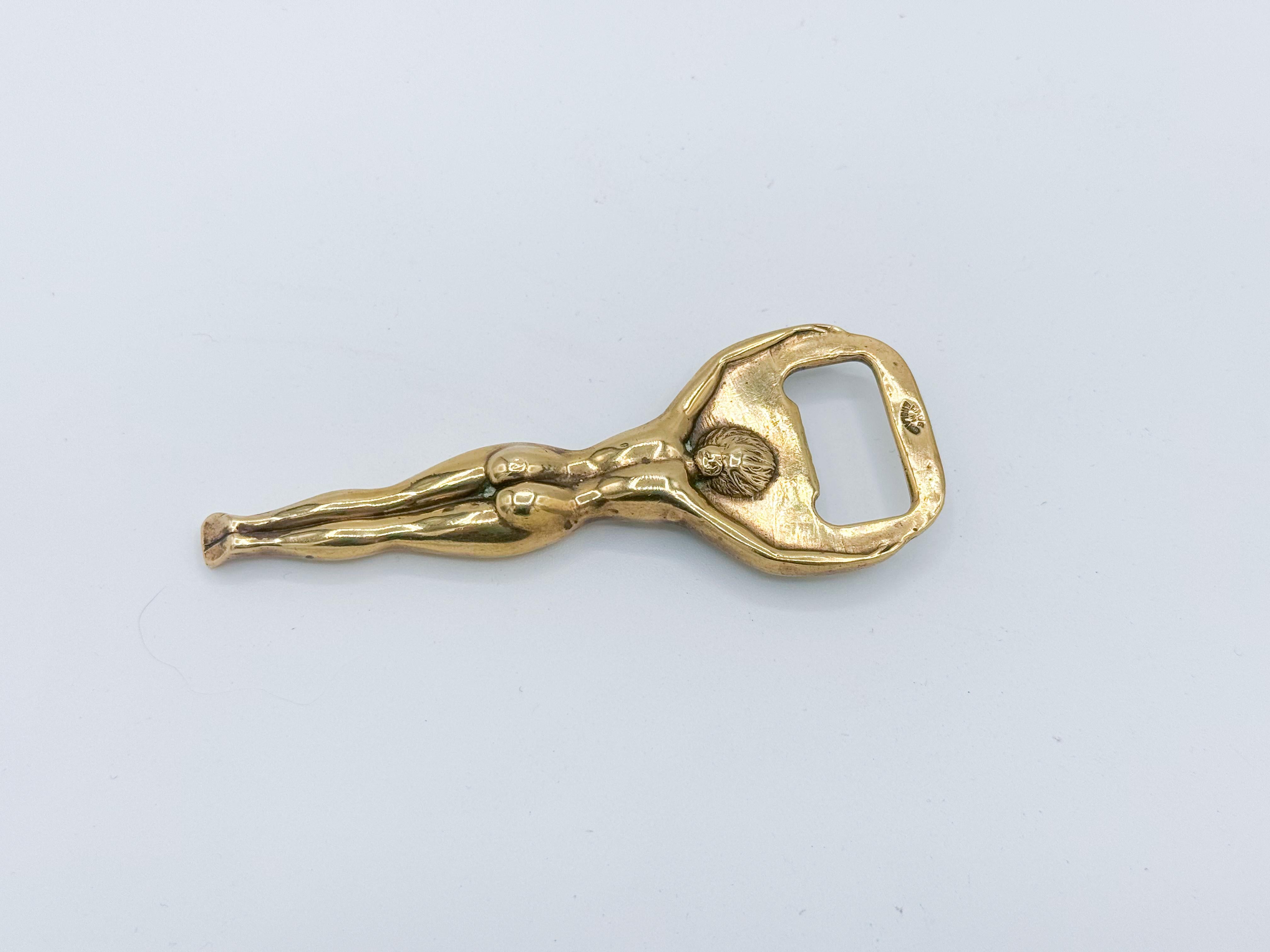 Add a touch of mid-century charm to your bar or collection with this Vintage Brass Nude Girl Bottle Opener from the 1970s. Crafted from solid brass, this unique and playful piece features a detailed nude female figure, blending art with
