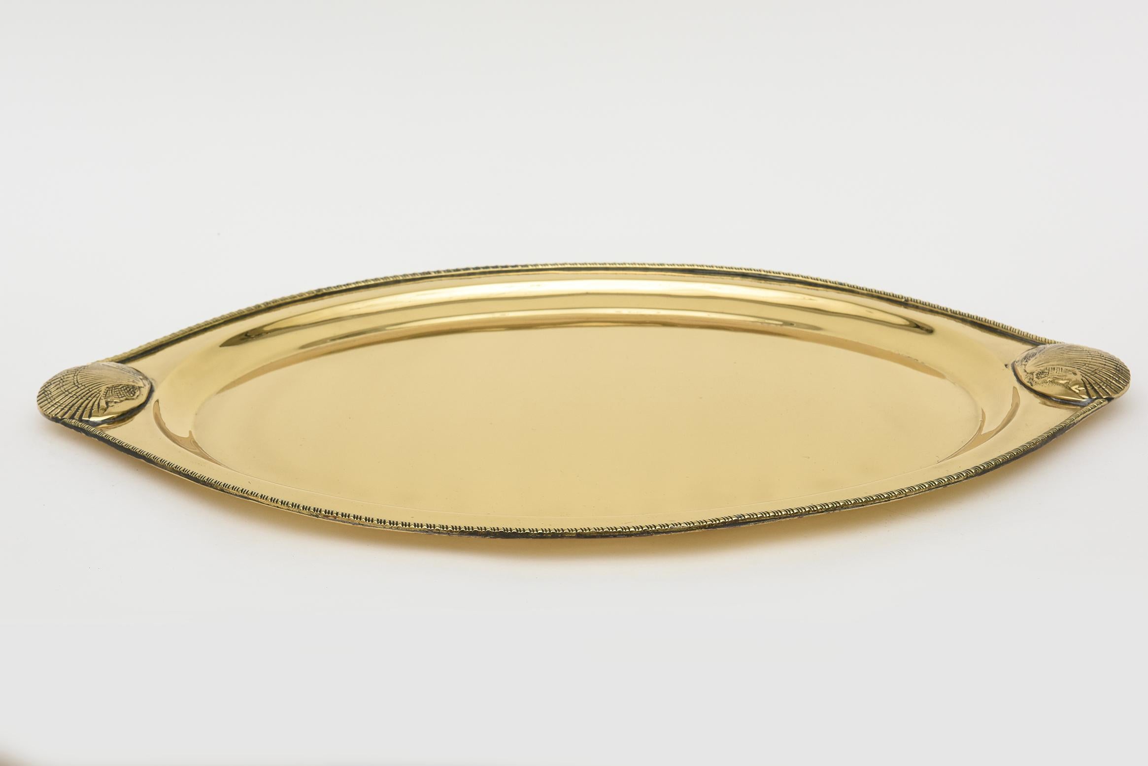 This lovely vintage brass large oval tray has 2 shell designs at both corners. There is a twisted design on the rim surround. It if from the 70's and has been polished and lacquered.  No maker marks. Nice weight. Barware.