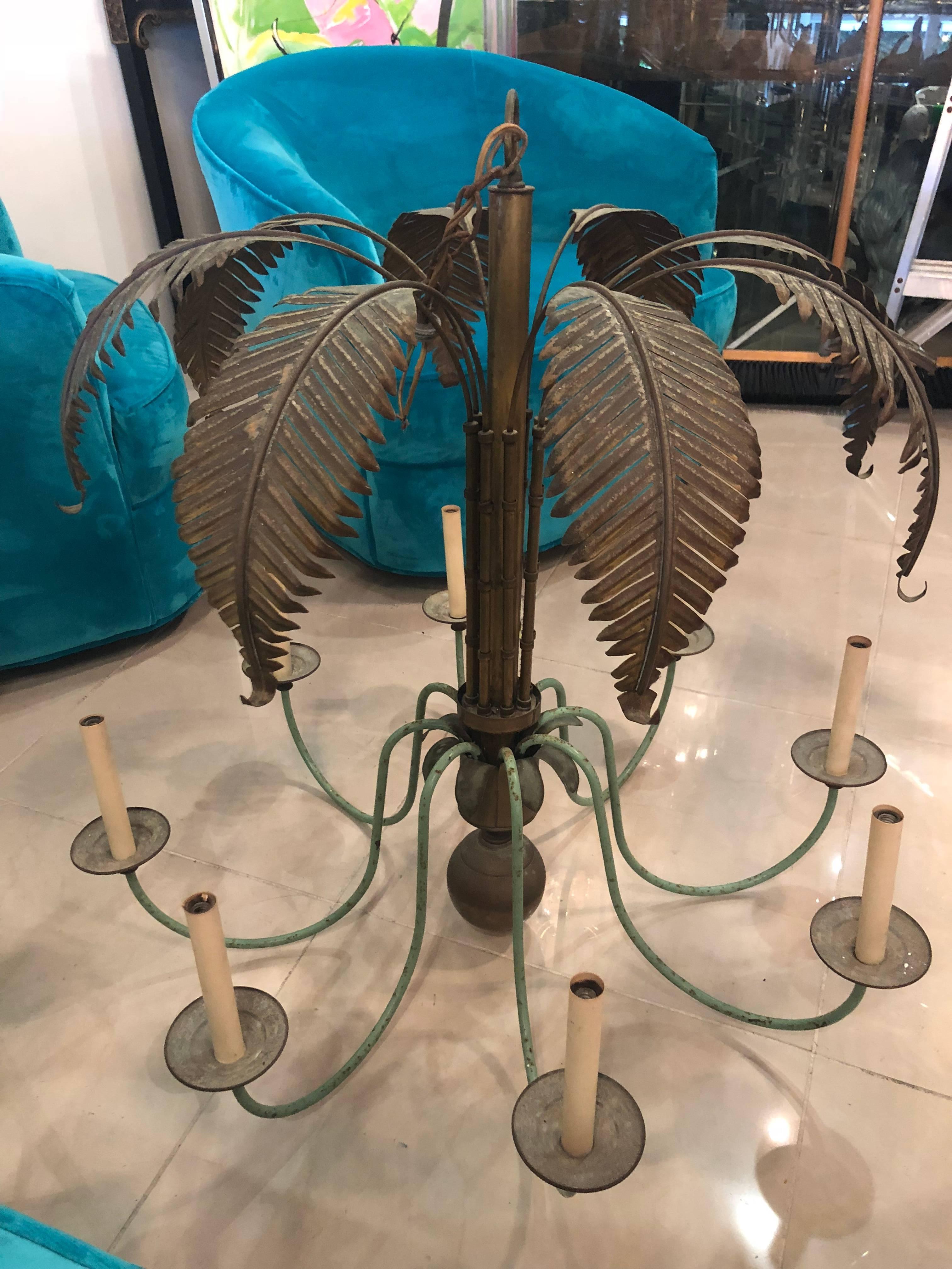 Vintage brass palm tree leaf frond chandelier. 8 lights. Comes with matching ceiling canopy. Candelabra sleeves and sockets will be newly replaced. This has not been polished and has patina and natural aging. The arms are a light green paint.
