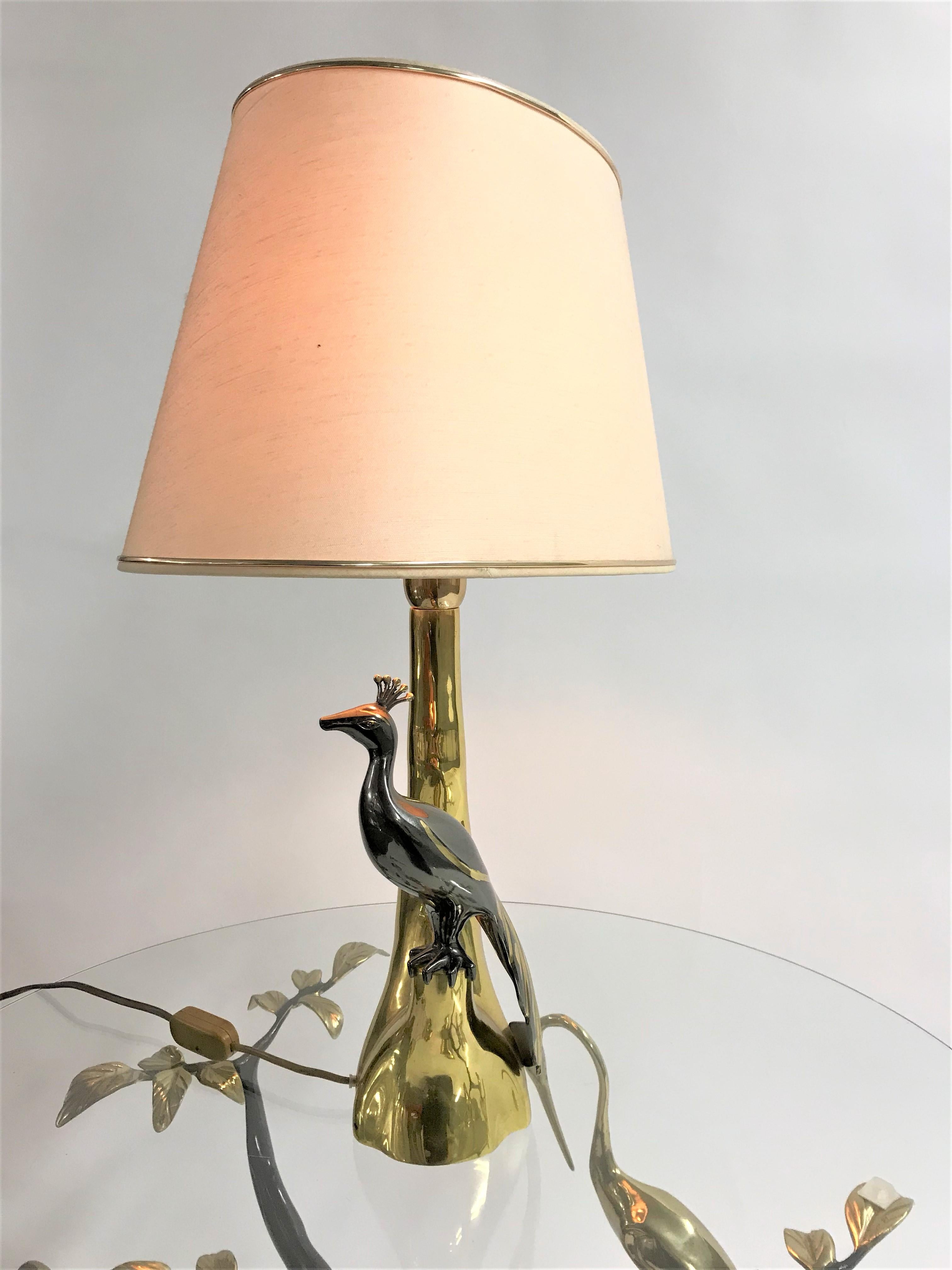Vintage brass table lamp depicting a peacock sitting on a branch.

The lamp was made by Willy Daro.

Good condition, tested and ready for use with a regular E26/E27 light bulb.

1970s, Belgium.

Dimensions:
Height 63cm/24.80