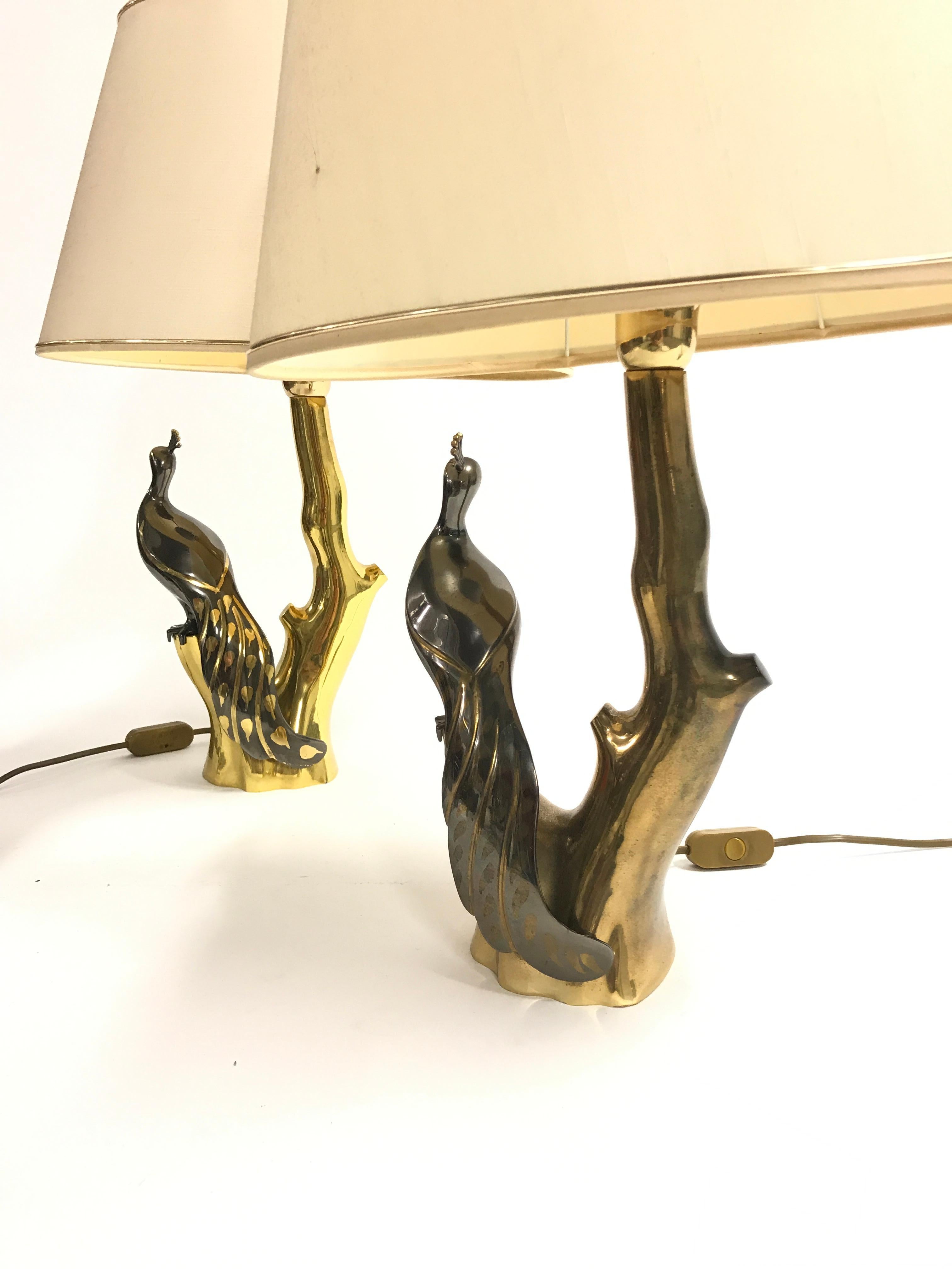 Pair of vintage brass table lamps depicting peacocks sitting on a branch.

The lamps where designed by Willy Daro.

Good condition, tested and ready for use with a regular E26/E27 light bulb.

Both lamps come with their original and good