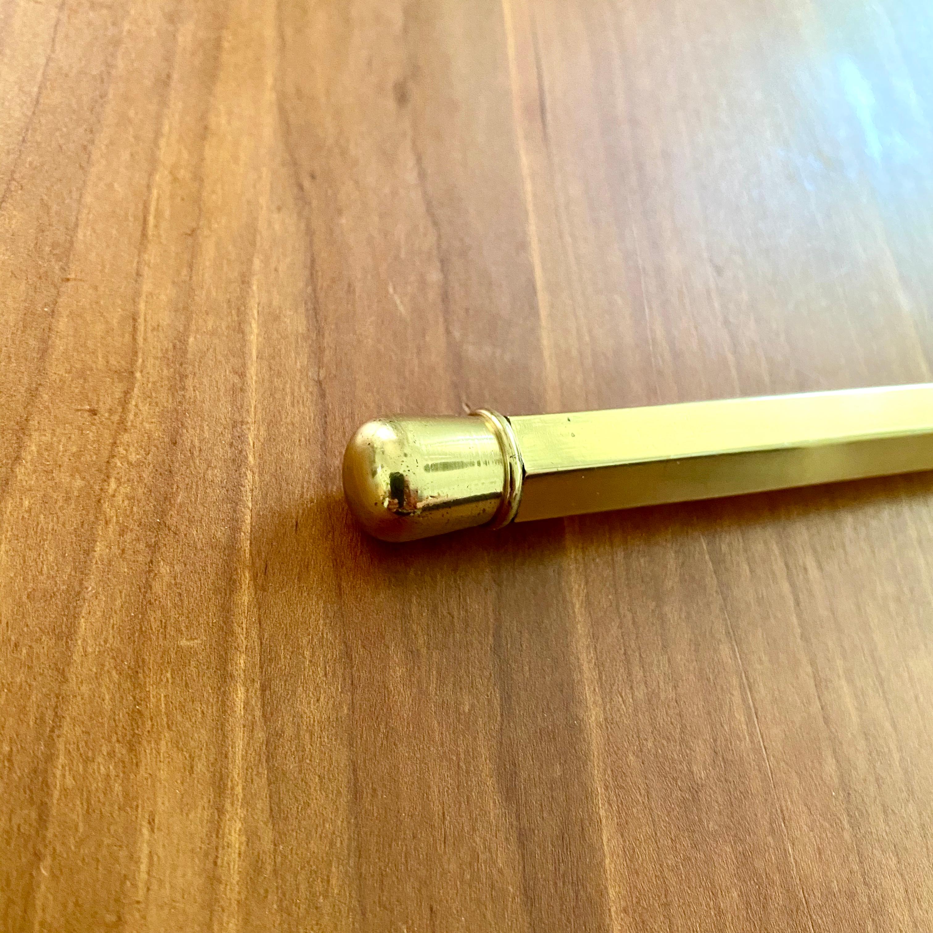 A vintage ink pen / rotary phone dialer / paper weight made of lacqered polished brass with an ink pen insert. The pen is model number 5037 and was designed by Carl Auböck of Werkstätte Carl Auböck in Austria. The pen is not signed, an original