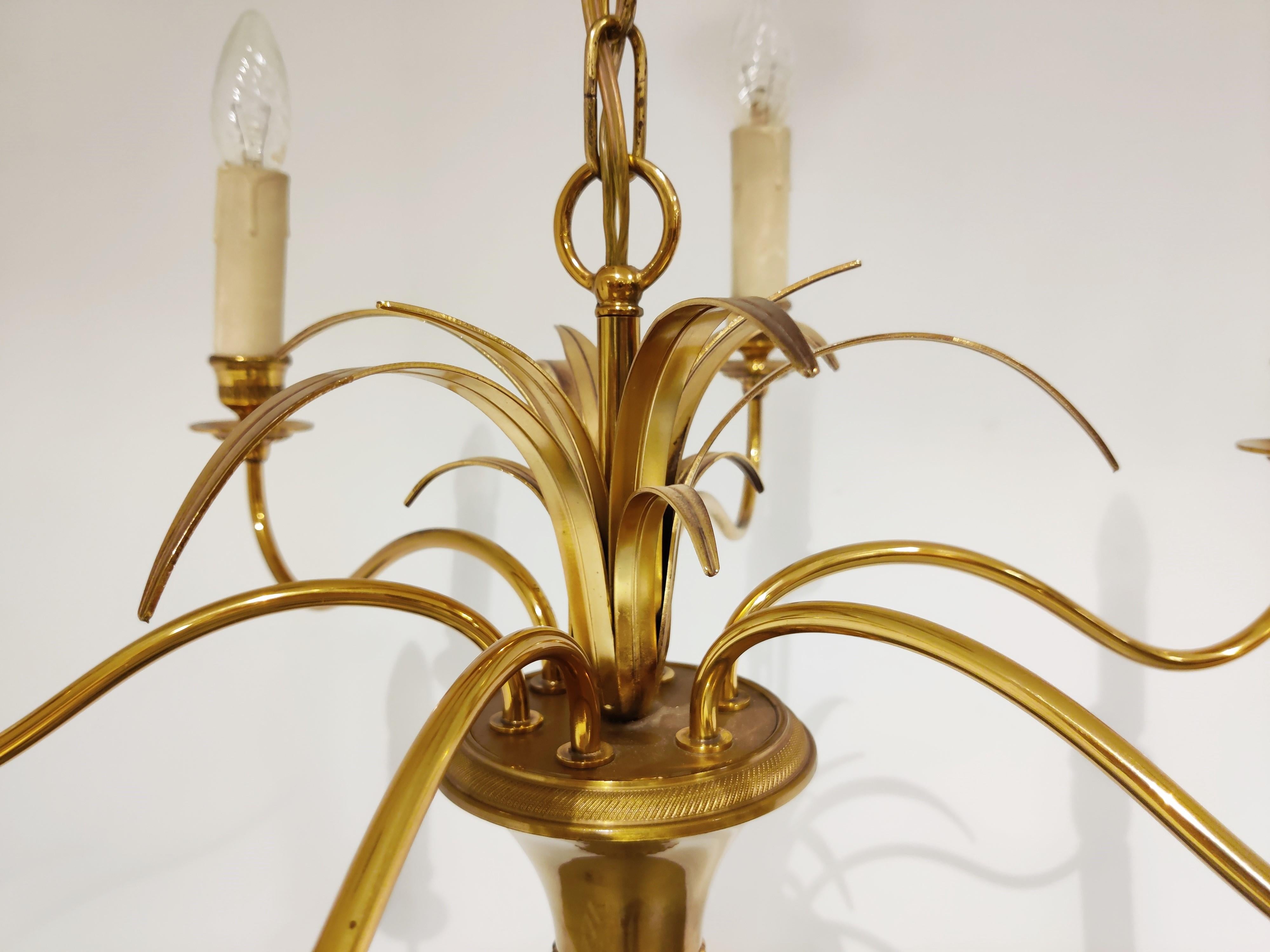 Beautiful, eye-catching pineapple leaf chandelier made from brass with six candelabra lightpoints.

This regency chandelier strongly resembles the style of Maison Jansen and has a highly detailed ormolu finial.

Very good condition.

1960s,