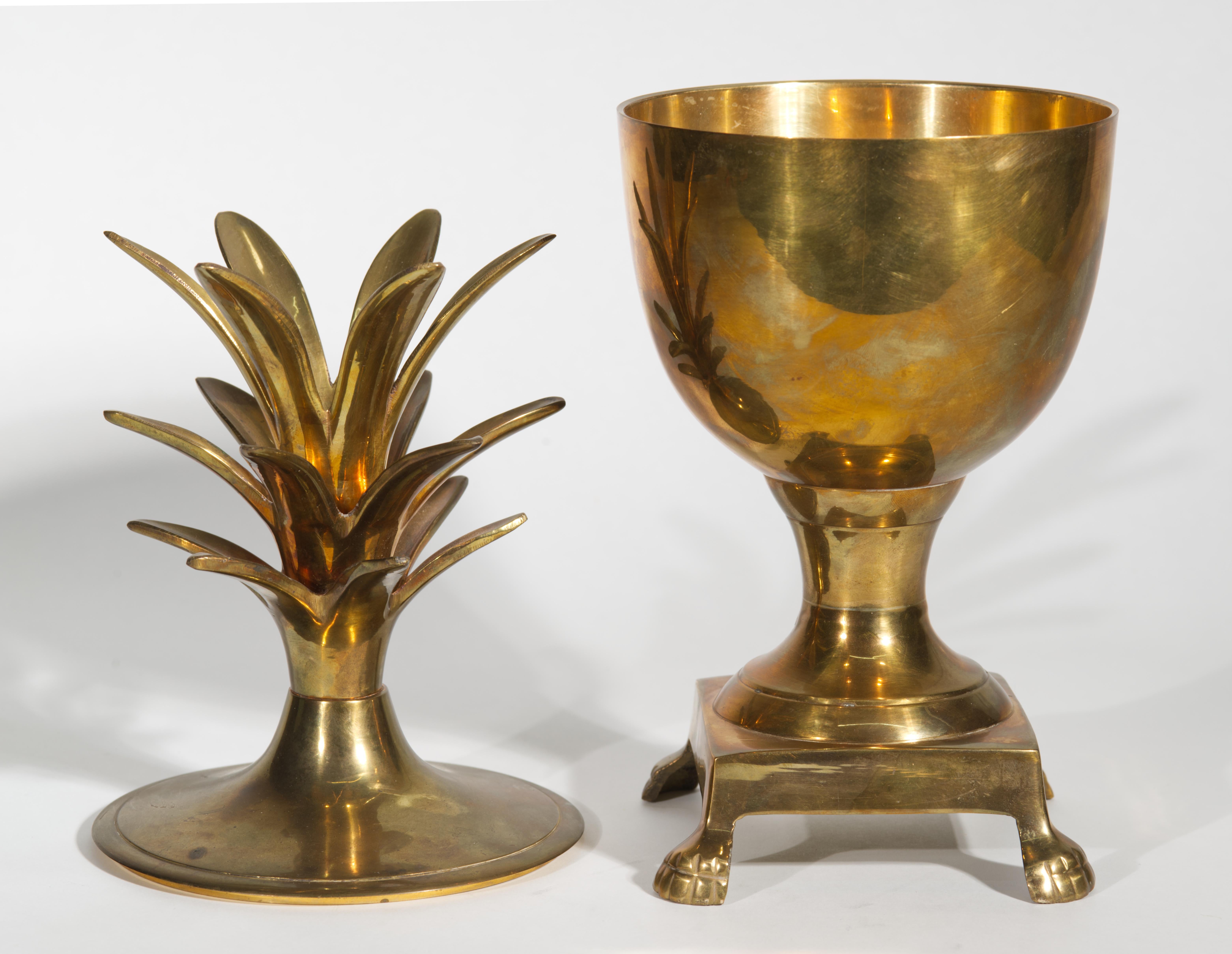  L'urne à couvercle ananas vintage en laiton massif présente un corps profilé, monté sur une base carrée avec des pieds en forme de pattes, et une poignée de couvercle à motif ananas à trois niveaux. Le design moderne du milieu du siècle avec une