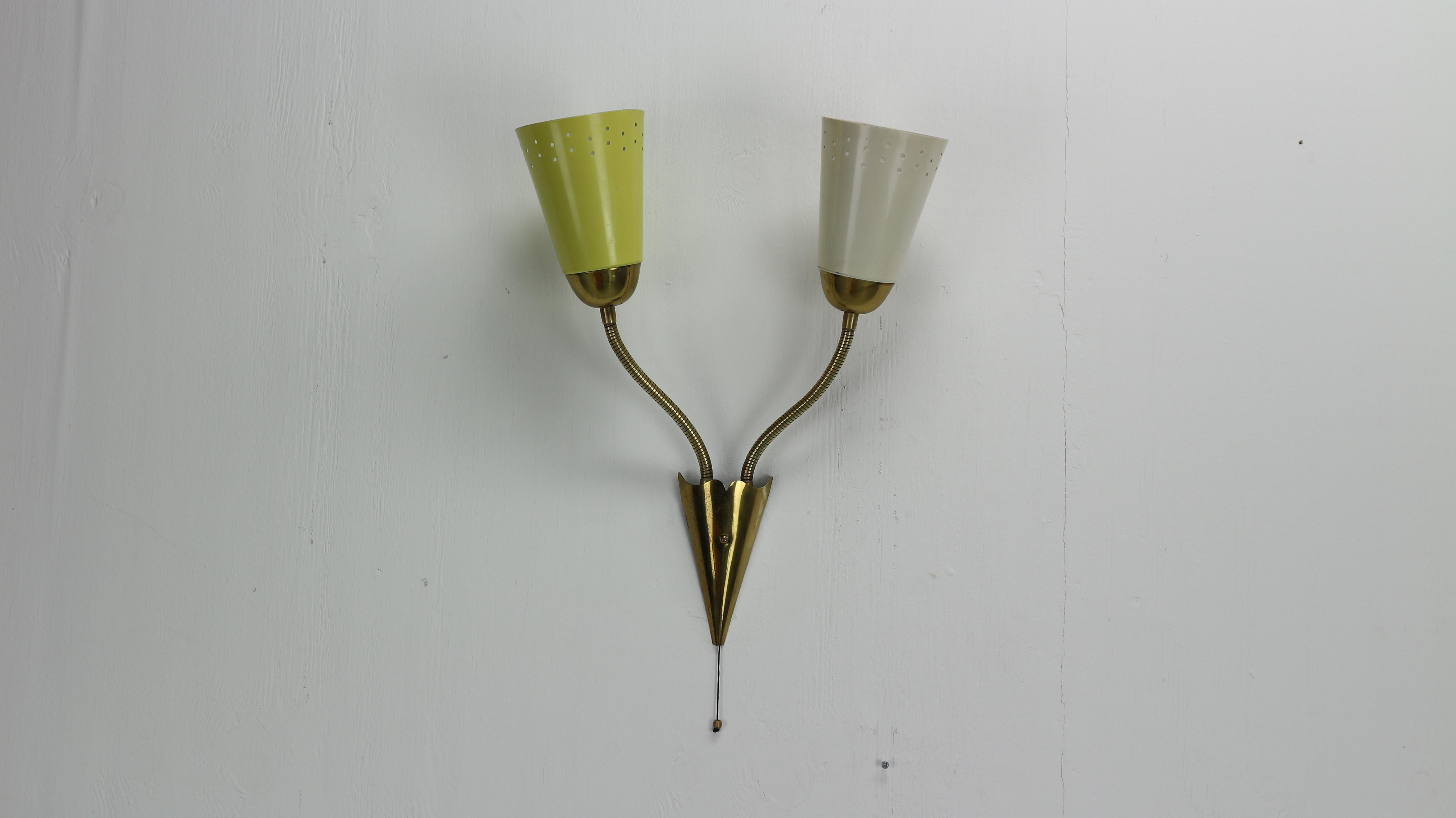 This two sconces hanging wall lamp is made from brass and perforated metal. The vintage design accent of Mid-Century Modern period.
You can rotate and adjust the lamp shades in any position to direct or not direct lightening.
Produced in the