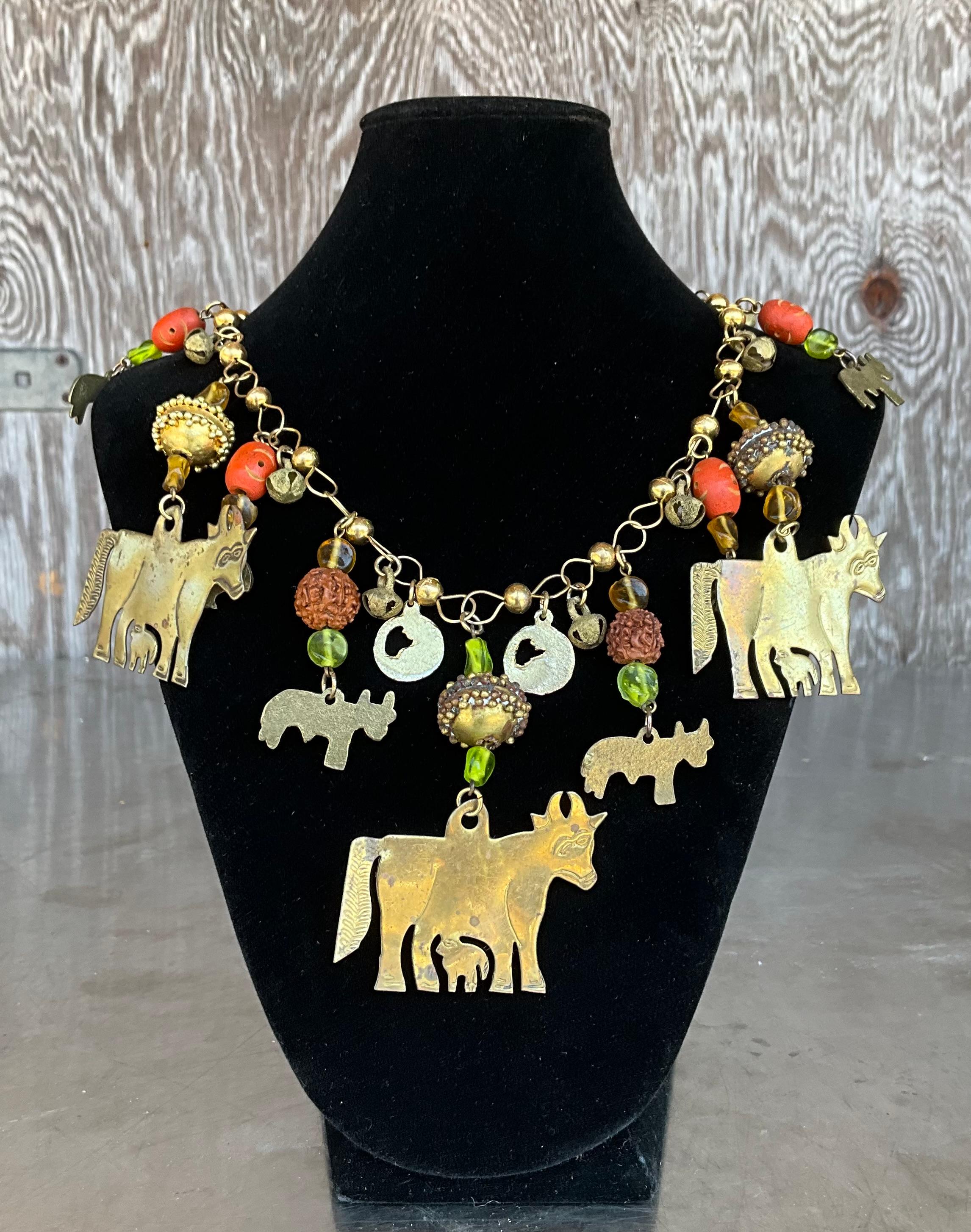 Diese Halskette aus Messing mit heiligem Stier ist ein kraftvolles Statement voller Symbolik und handwerklichem Charme. Diese Halskette mit mehreren kühnen Messinganhängern eines heiligen Stiers, der in alten Kulturen als Symbol für Stärke, Schutz