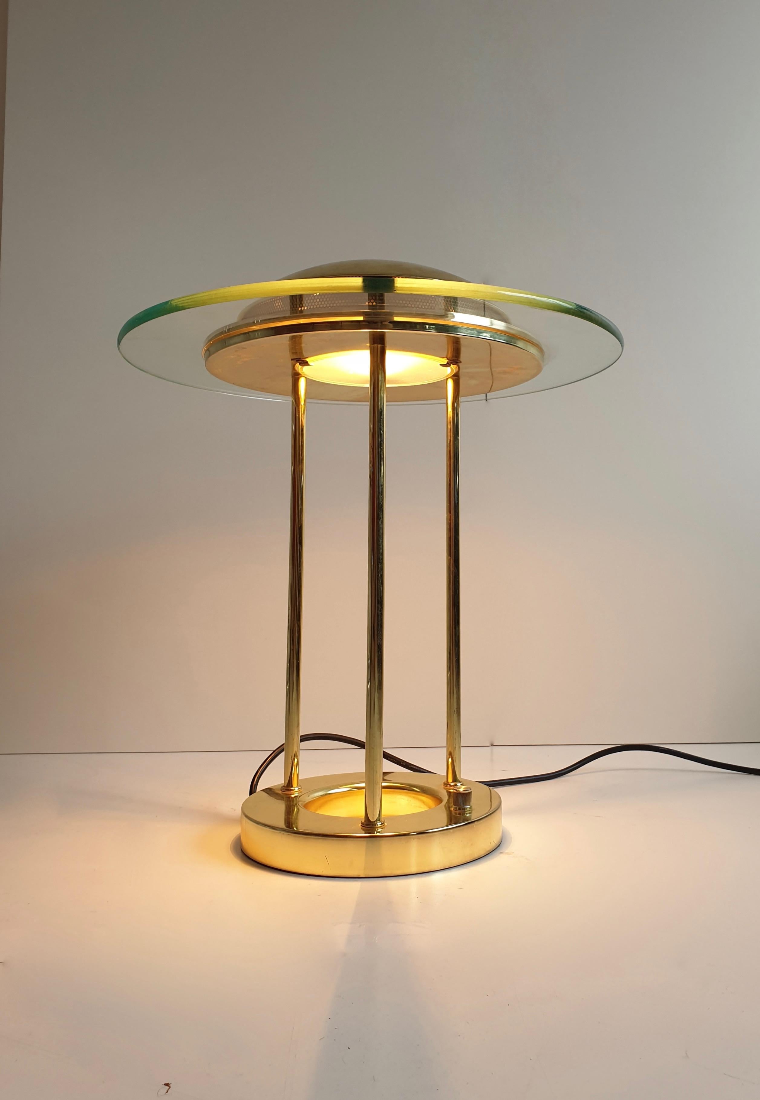 Vintage brass 'Saturn' lamp by Robert Sonneman for George Novak. Inspired by Saturn, it features a glass ring around its round dome shade, resting on three straight brass rods on a polished zinc base. The light level is adjustable via a brass rotary