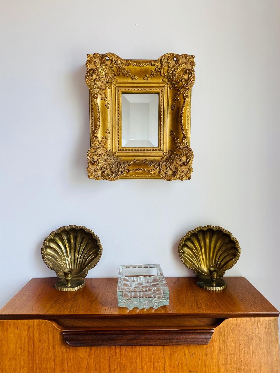 Incredible pair of vintage wall candle holders that can hang on a wall or stylishly rest on a flat surface. This beautiful pair brings out old Hollywood style and glamour to your décor. The scallop profile against brass and candle light will make