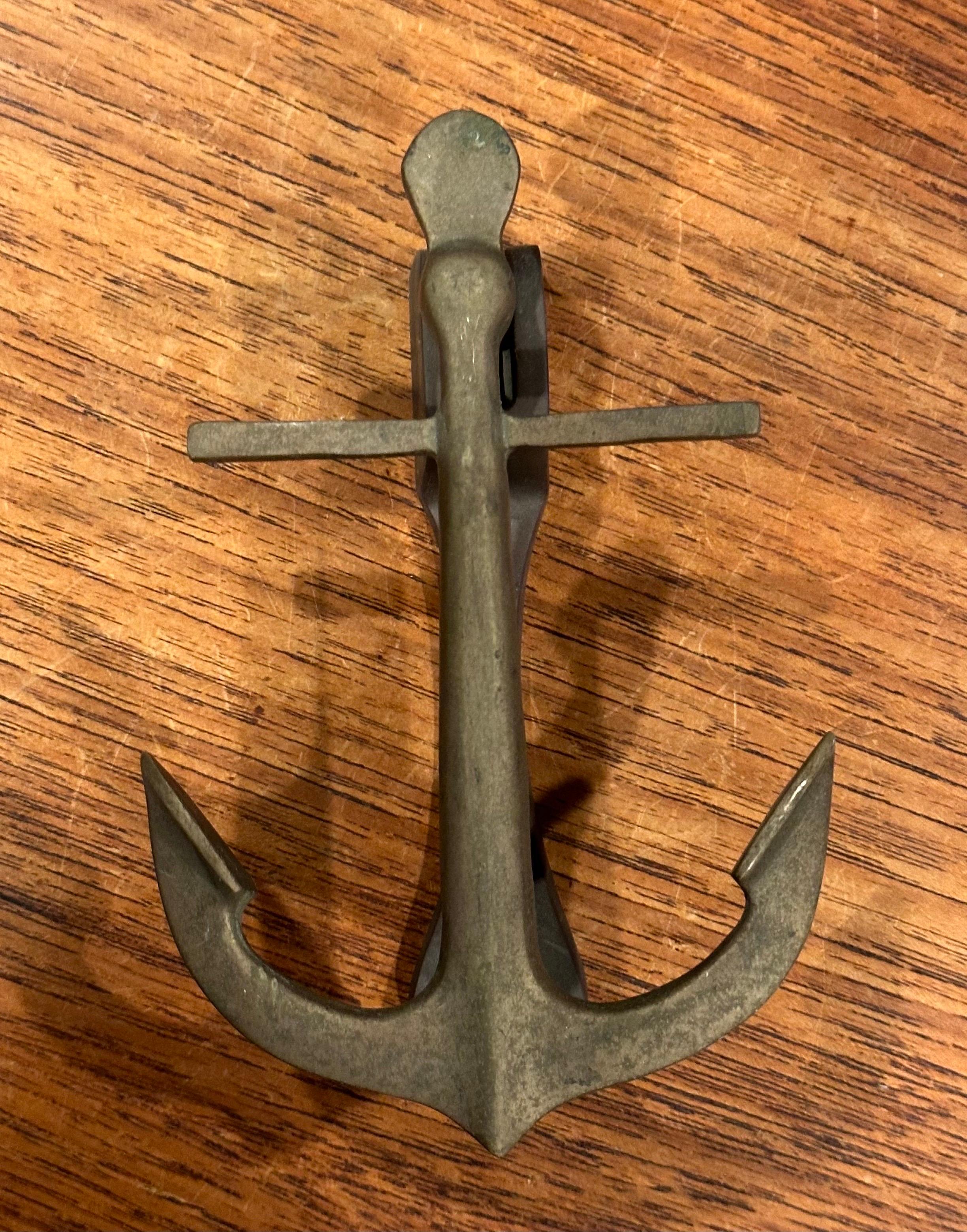 Well worn vintage brass ship anchor door knocker, circa 1960s. The piece is made of cast brass and is quite solid. The knocker is in very good vintage condition and measures 4