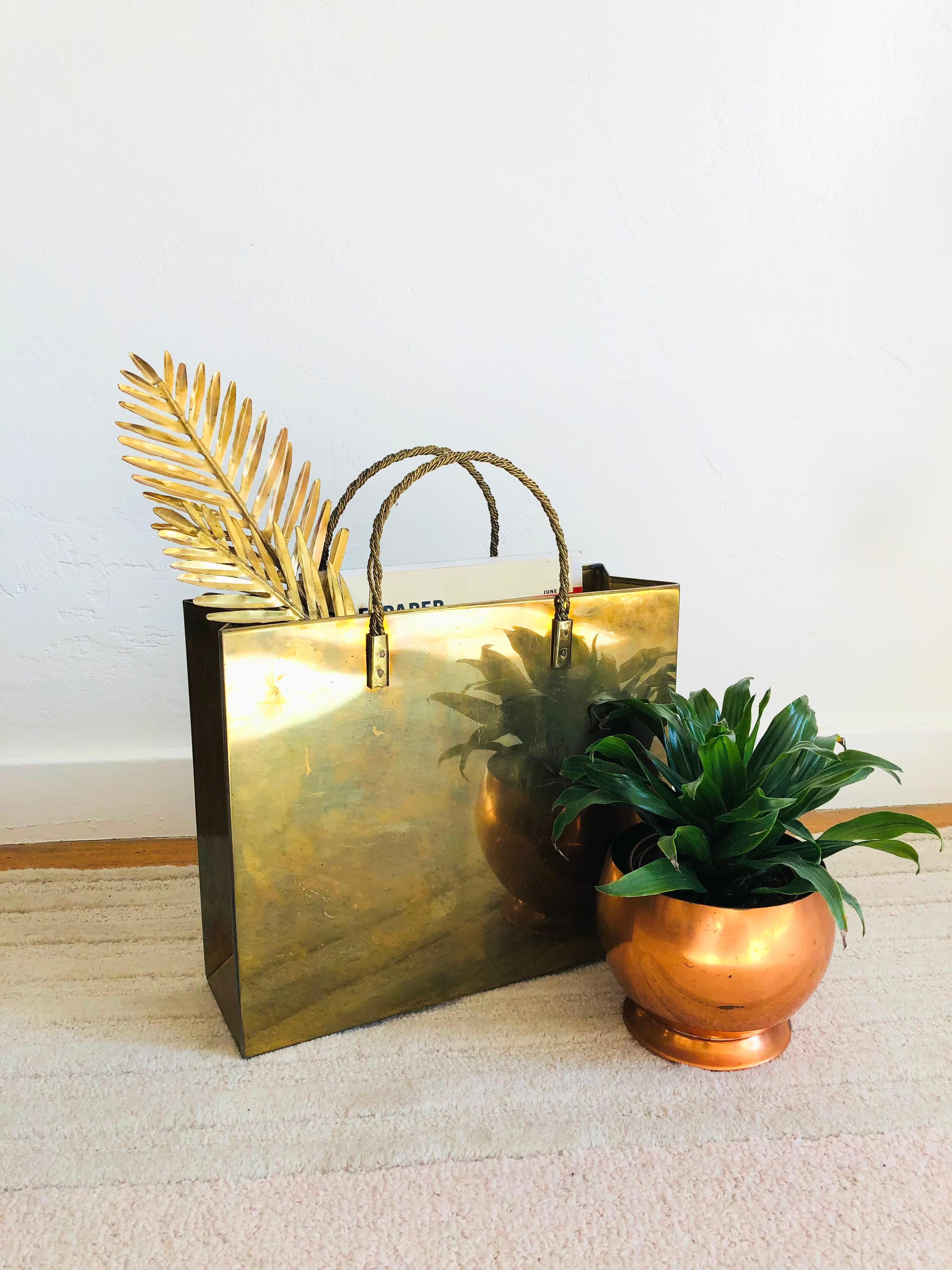 A vintage brass magazine rack, designed in the shape of shopping bag attributed to Italian designer, Gio Ponti. Nice rigid shape with stiff woven brass handles at the top with a slim profile and small footprint. Perfect for using as magazine or file