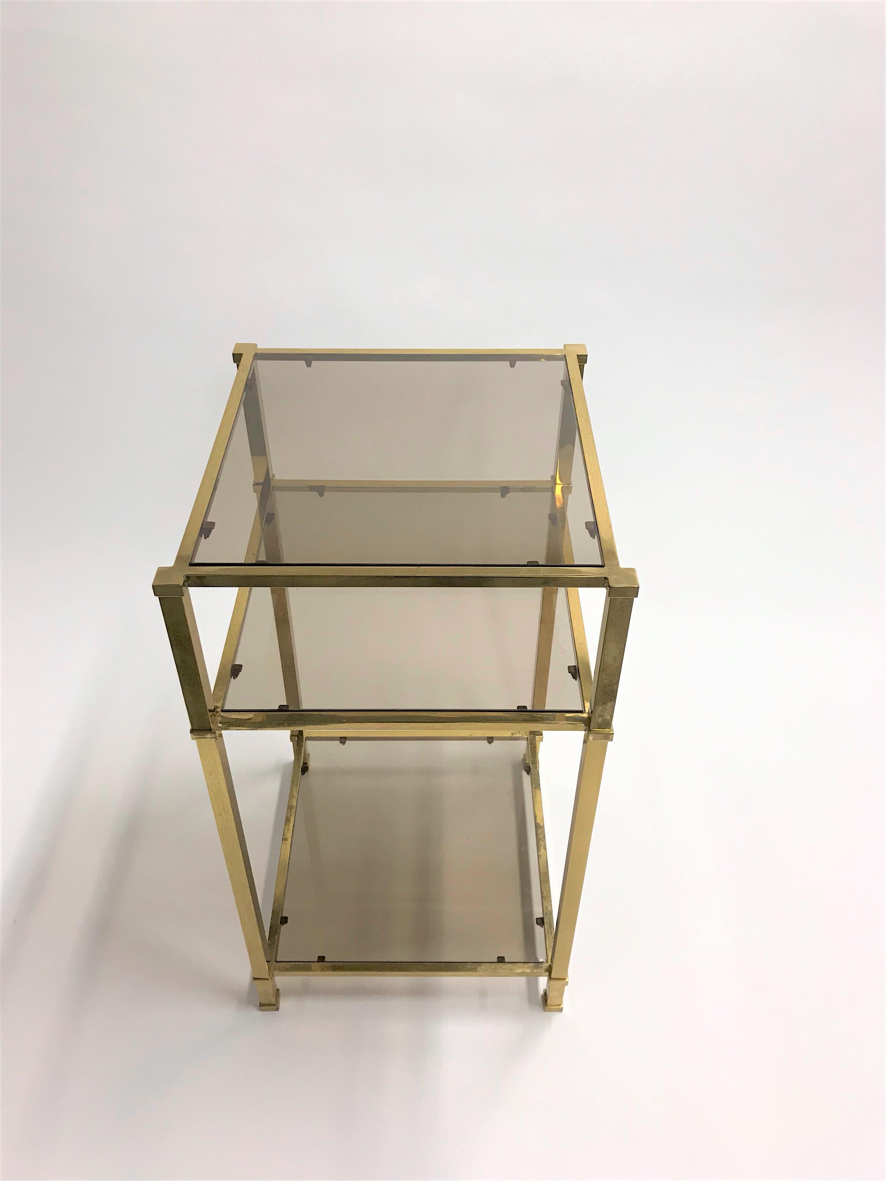 Brass tree tier smoked glass side table.

This Hollywood regency side table is rather unusual due to it's three glass layers.

Ideal to use as a display table or side table.

Good condition, slight patina on the brass.

Belgium,