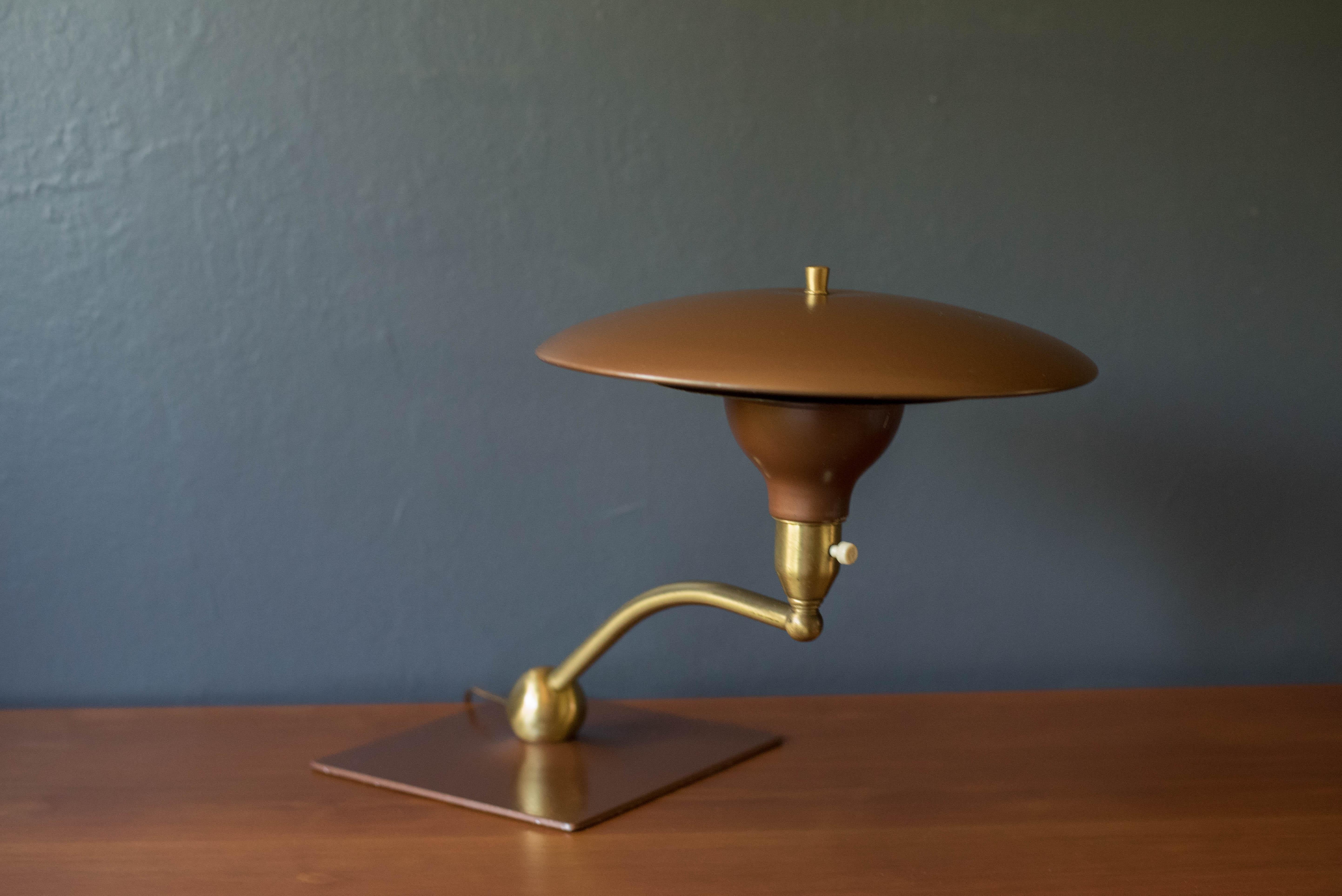 Vintage sight light desk lamp manufactured by M.G. Wheeler Company, circa 1960's. Features a rotating swivel arm and supporting weighted brass base. Perfect to use as an office desk lamp or reading light. This unique piece pairs well with art deco