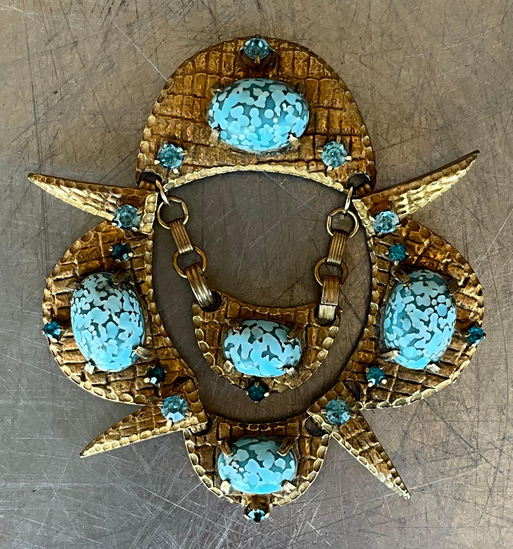 A vintage brass soapstone brooch combines the warm, earthy appeal of soapstone with the rich, rustic look of brass, creating a beautiful piece of jewelry that is often both striking and unique. The combination of these two materials makes for an