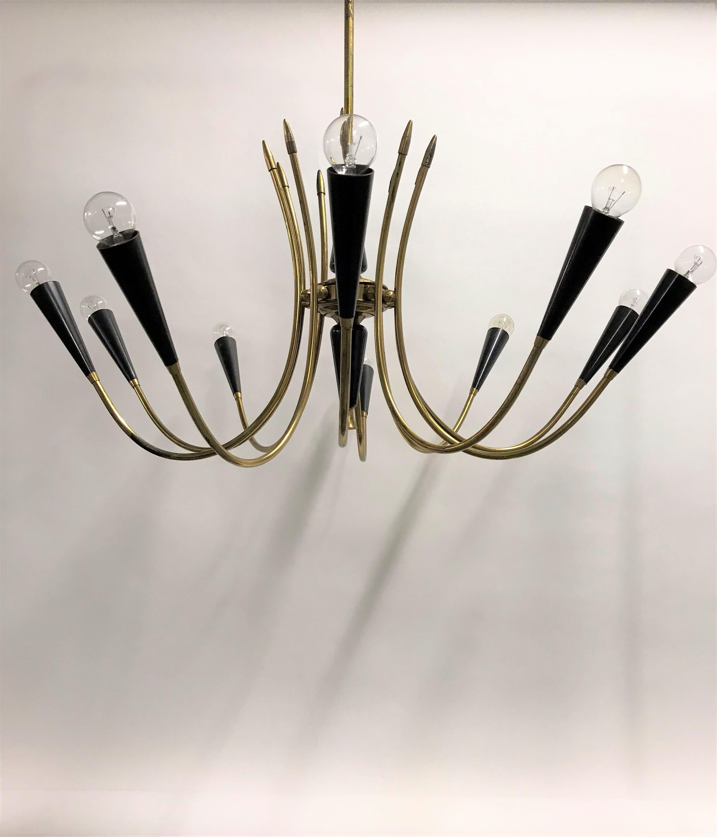 Beautiful midcentury 10-arm spider chandelier made from brass and lacquered metal. The light bulb holders are made from Bakelite.

This charming high-quality chandelier is a wonderful original piece that could be the perfect finish for a living