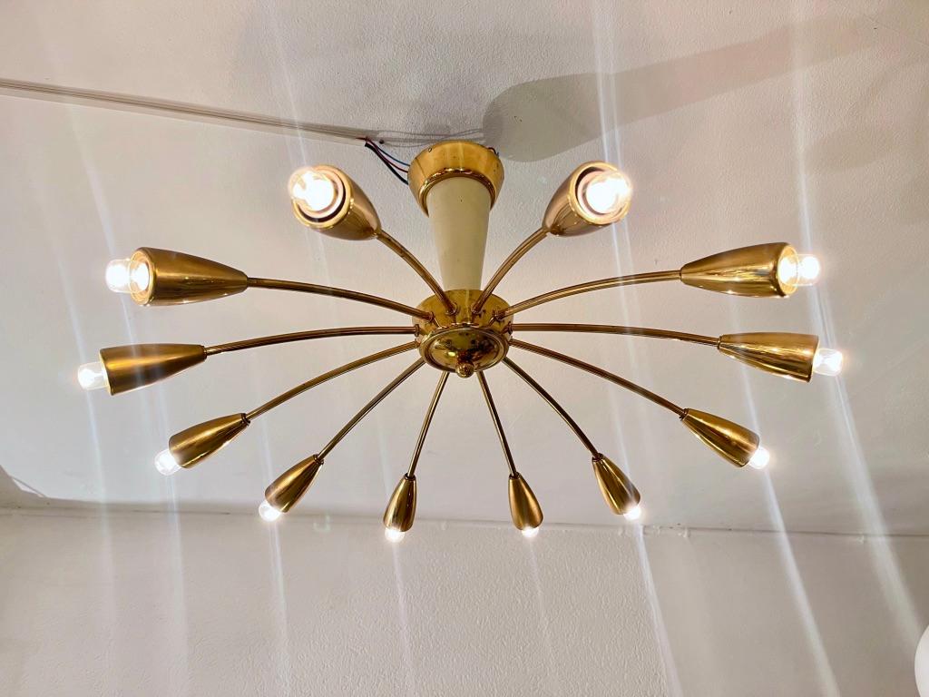 Vintage 12 brass arms Sunburst flush mount ceiling lamp. Made in Switzerland in the 1950s by the famous brand BAG Turgi.
Very good condition. 
Diameter 65 cm, Height 40 cm

