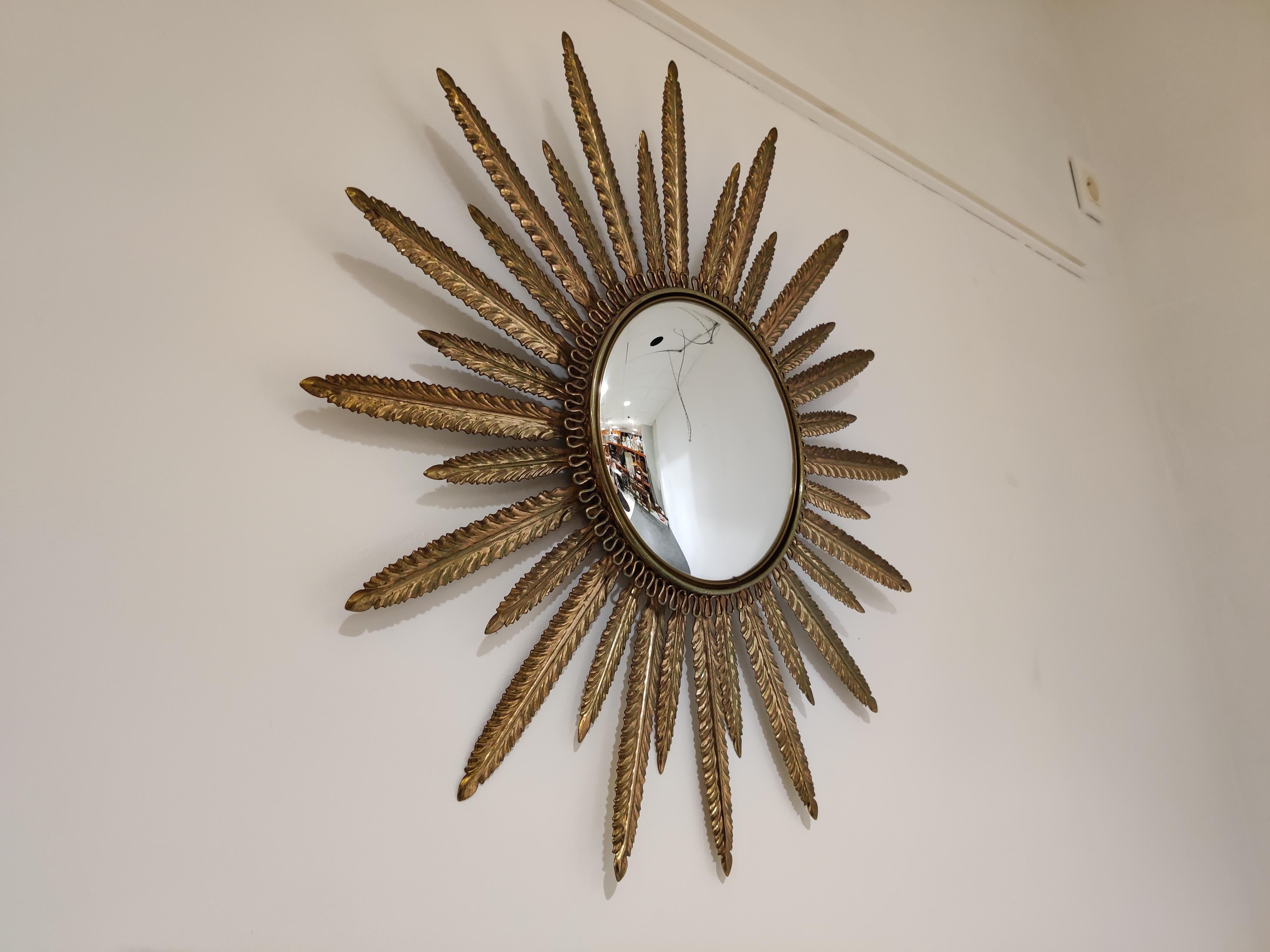 Midcentury brass sunburst or flower mirror with convex glass.

This mirror fits in most interiors and is a perfect add-on for a Regency style interior.

The mirror is made from patinated brass.

Good condition.

France - 1960s

Measures: