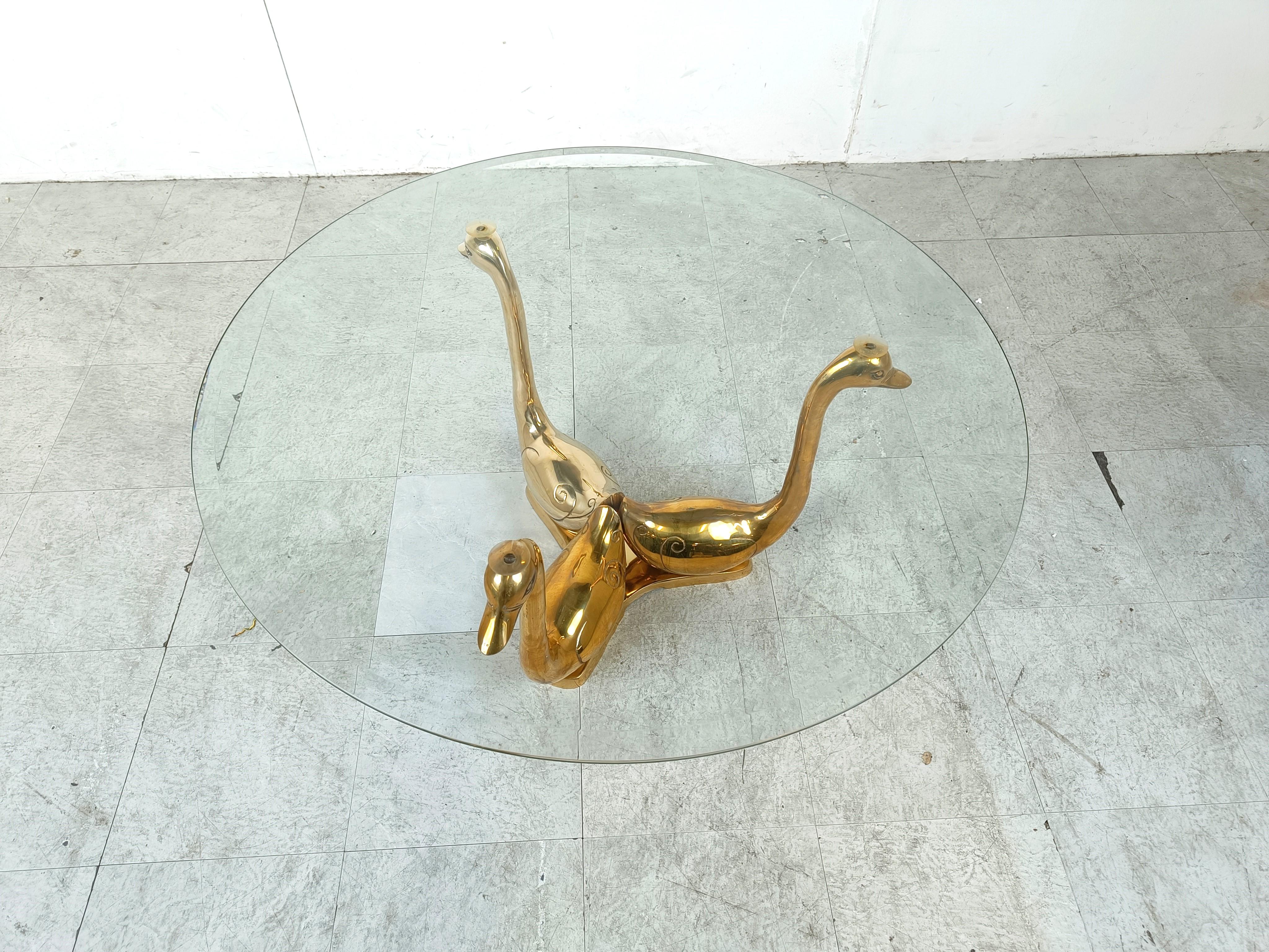 Hollywood regency brass swan coffee table.

The coffee table consists of a brass base featuring 3 brass swans and a round clear glass top.

We have a pair of these available.

Diemensions:
Height: 46cm/18.11