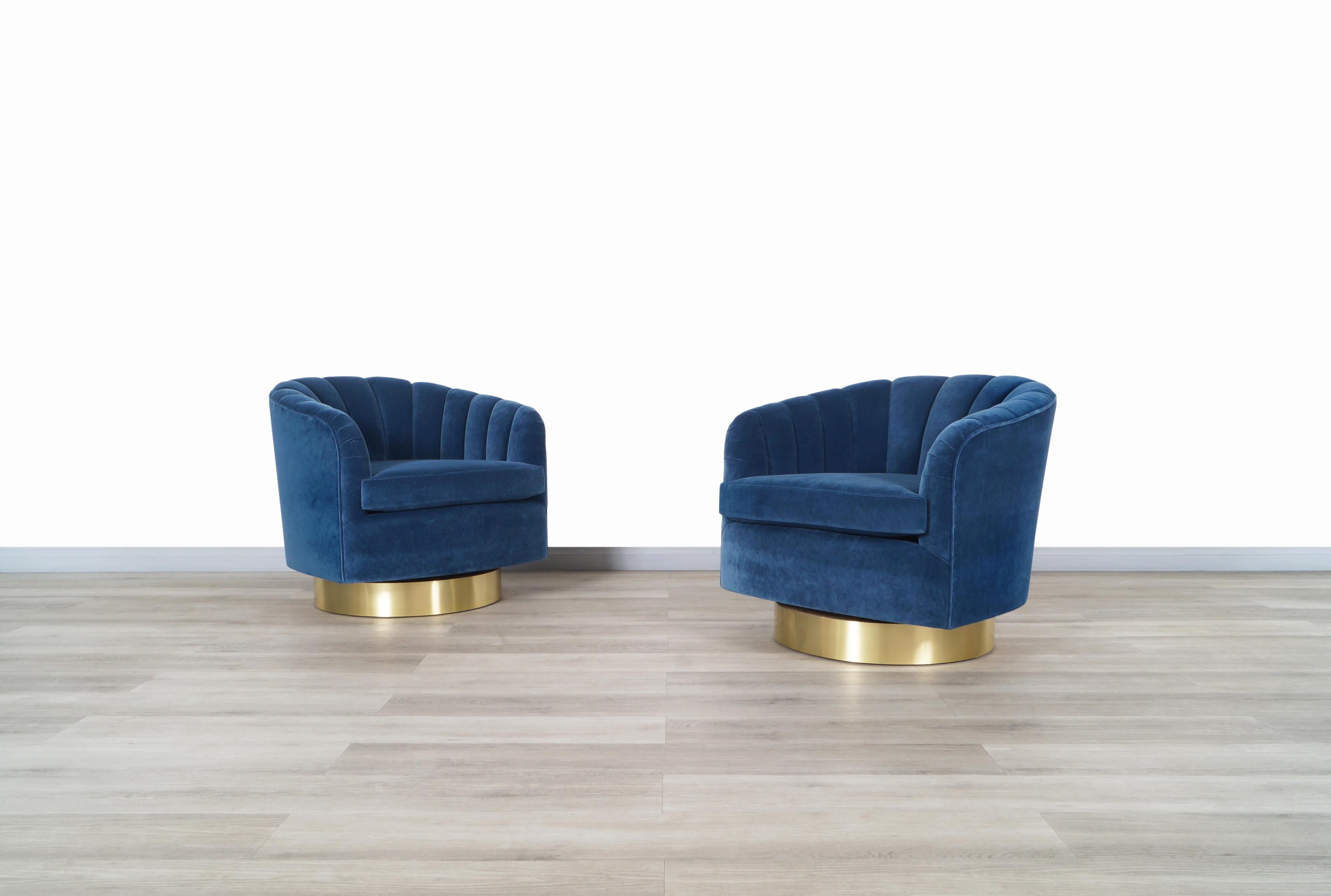 Wonderful vintage brass swivel lounge chairs designed by Milo Baughman in United States, circa 1970s. These chairs have been professionally reupholstered in soft royal blue velvet by our expert craftsmen. The circular design of the chairs makes them