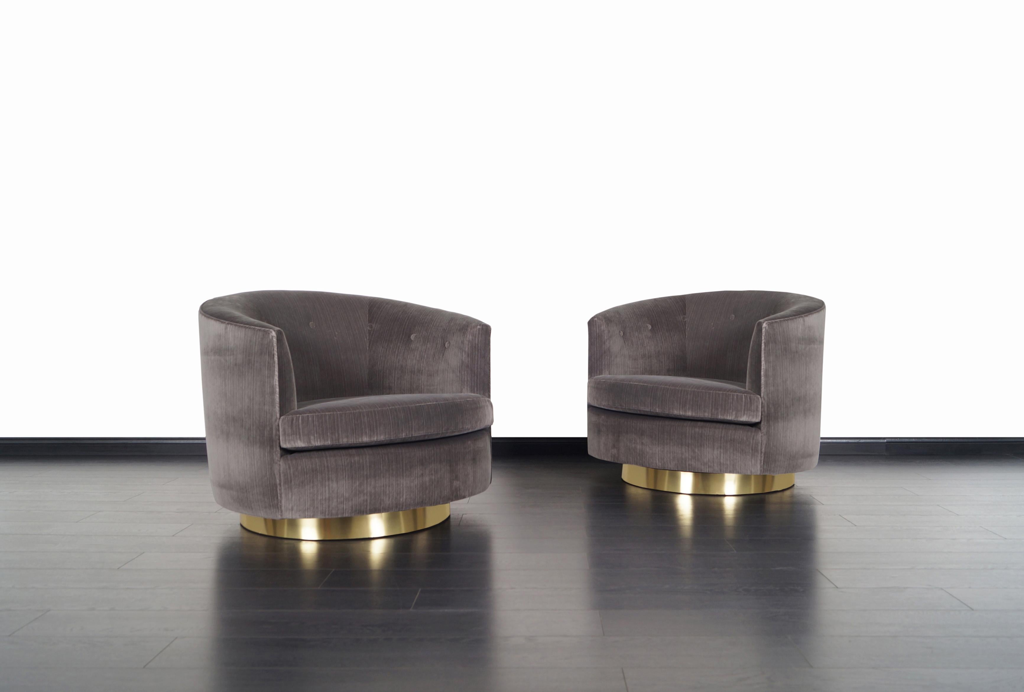 A stunning pair of vintage swivel lounge chairs designed by Milo Baughman for Thayer Coggin. Each chair has a circular brass base that rotates 360 degrees with ease. They're also extremely comfortable. The chairs have been professionally