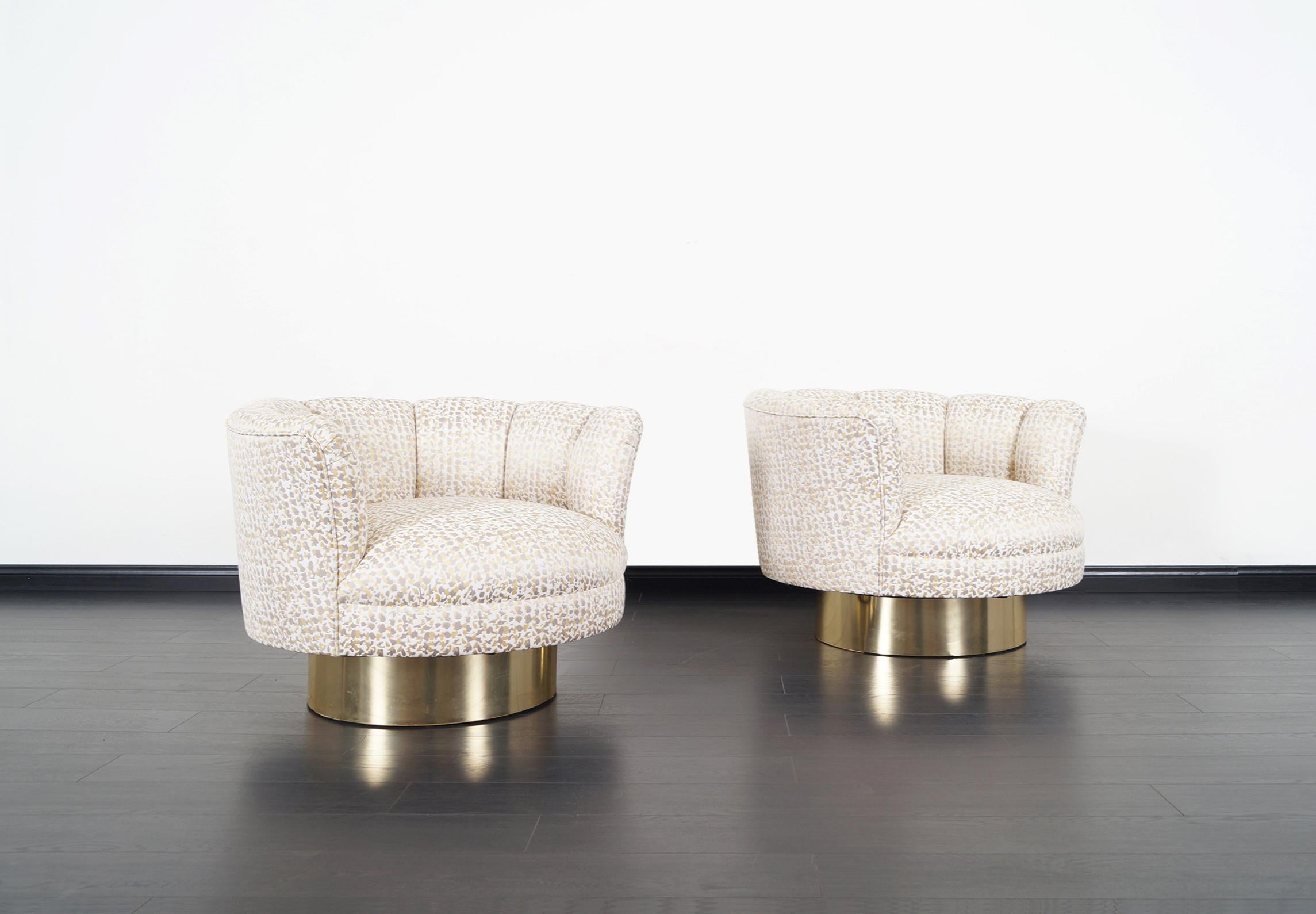 An exceptional pair of vintage swivel lounge chairs designed by Milo Baughman. Each chair has a circular brass base that swivel with ease. The chairs are newly reupholstered in custom fabric.