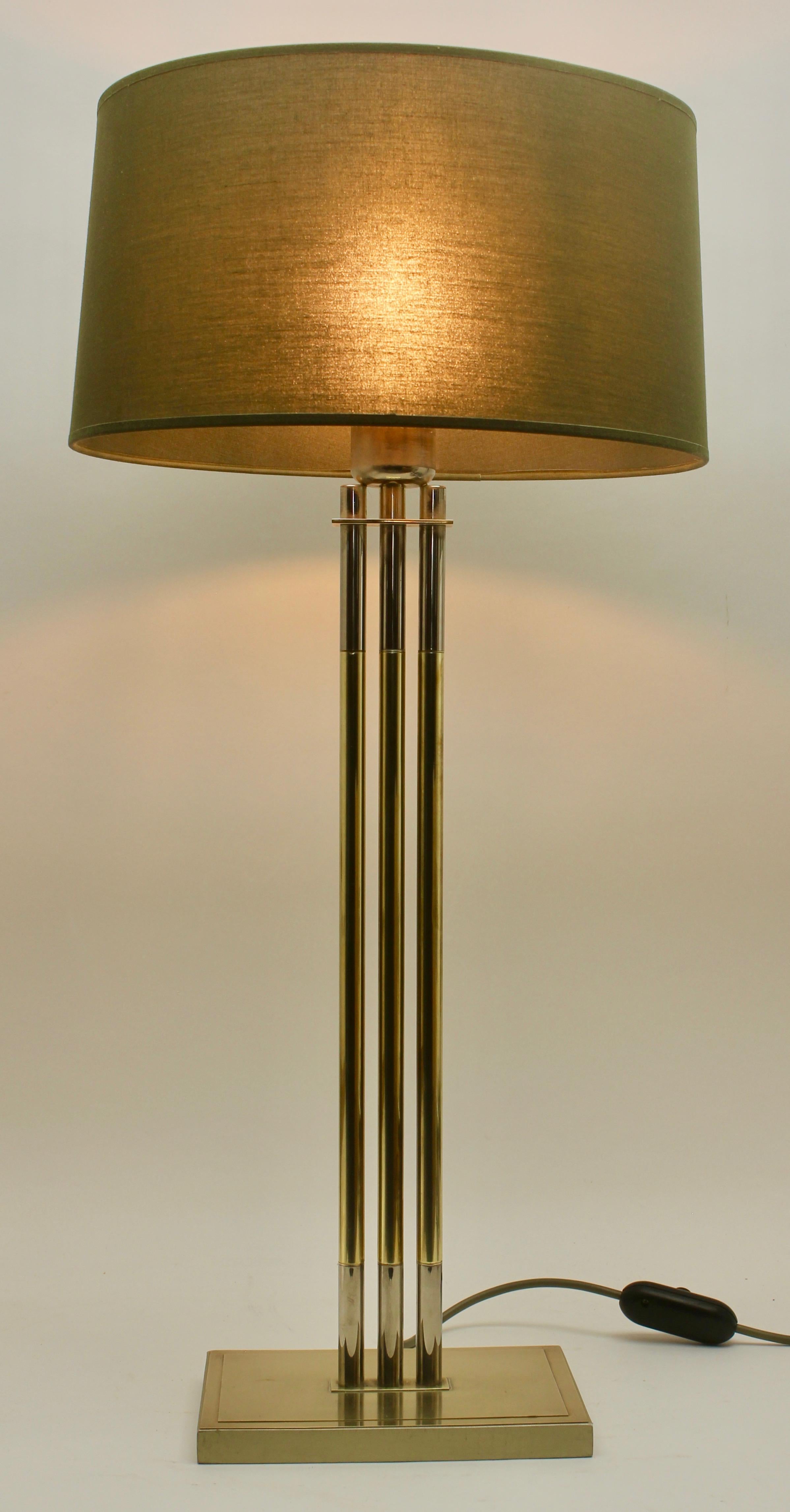 Vintage design
This 1970s table lamp by Lusterie De knudt Belgium features three brass columns with chrome details.
Patina consistent with age and use
Labeled by maker, numbered 3784

Important: The lampshade is included in photos for illustration