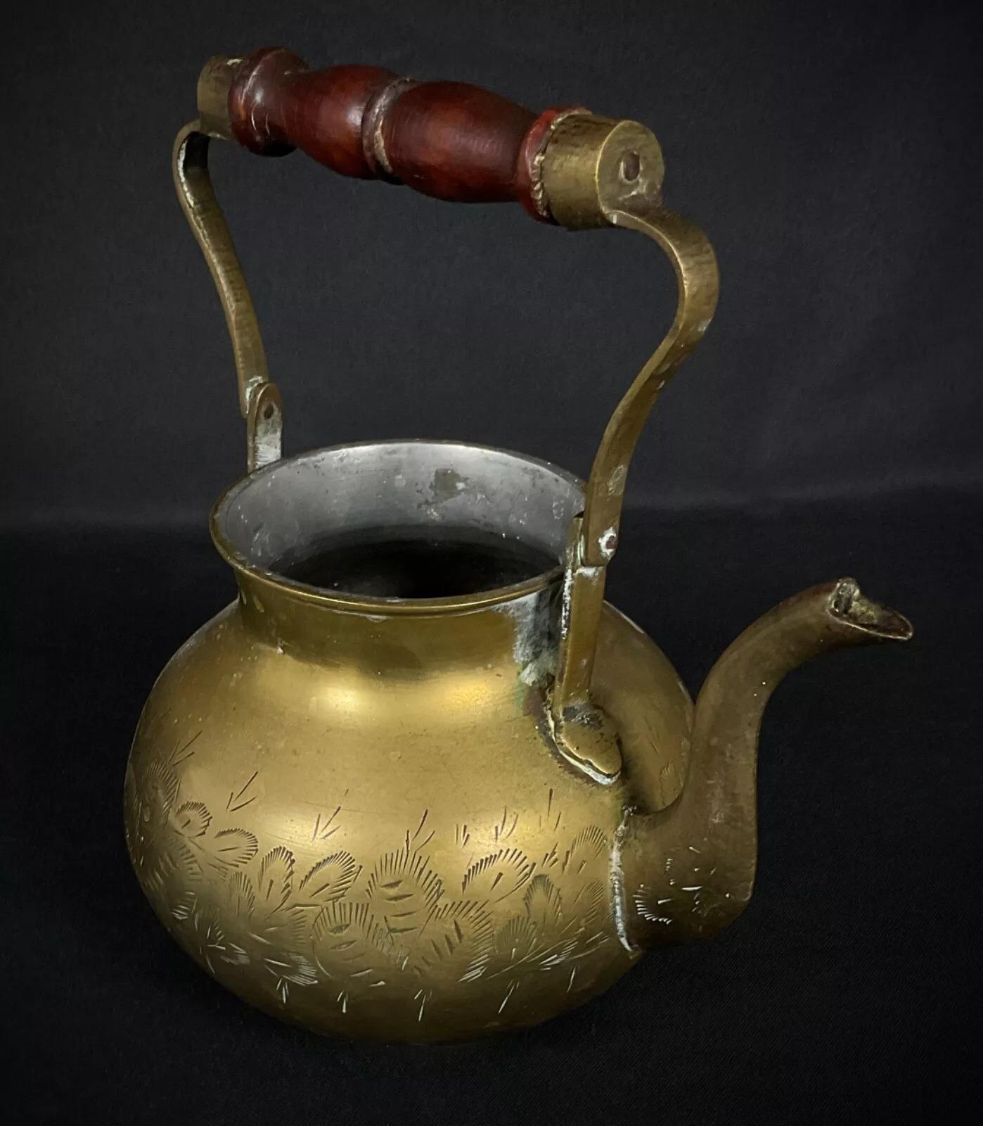 This vintage brass teapot, likely of Indian origin, is beautifully etched with intricate designs, making it an elegant and collectible piece. Crafted in the 20th century, the teapot has a warm brass patina and decorative detailing. Though it lacks a