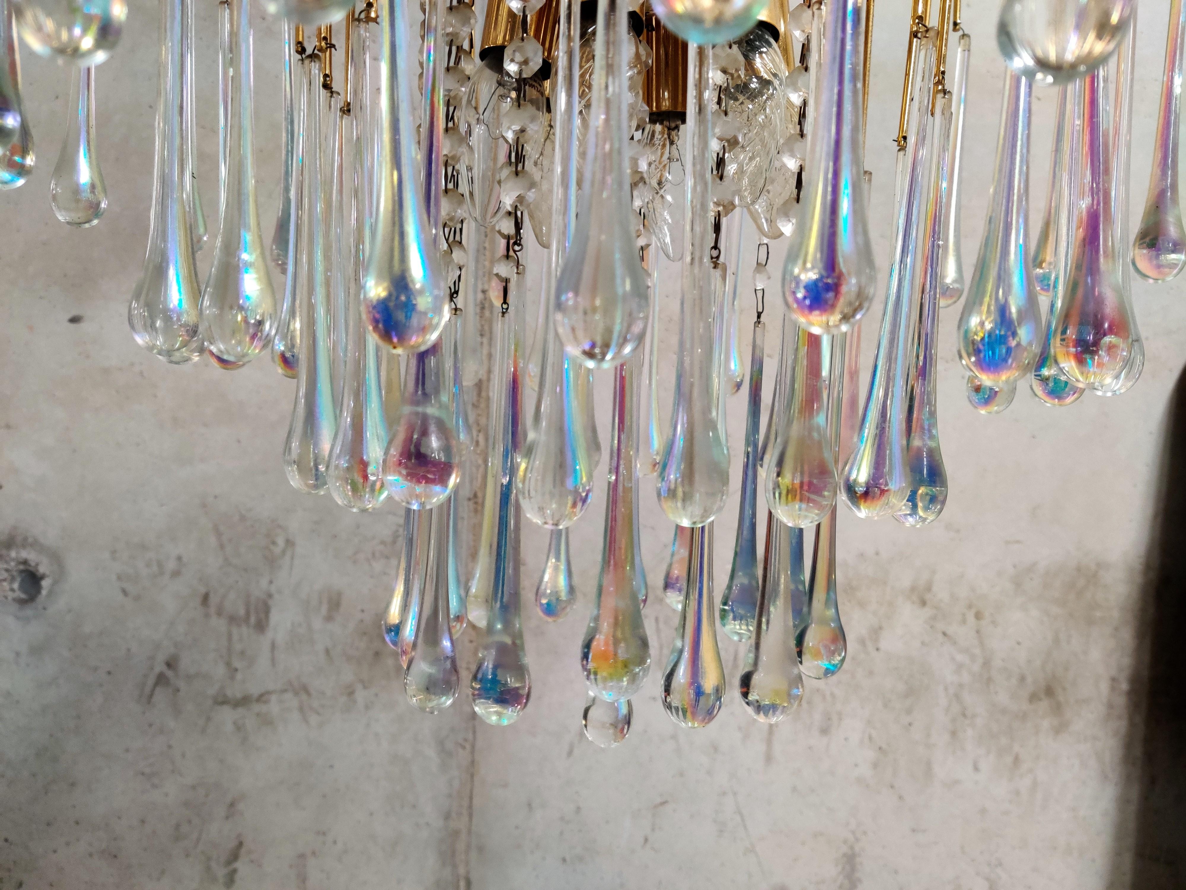 Elegant brass and Murano crystal chandelier.

The lamp is decorated with hand blown crystal Murano teardrop glasses.

The chandelier emits a stunning light.

The lamp is fitted with 6 E27 light sockets.

It comes with its original chain and