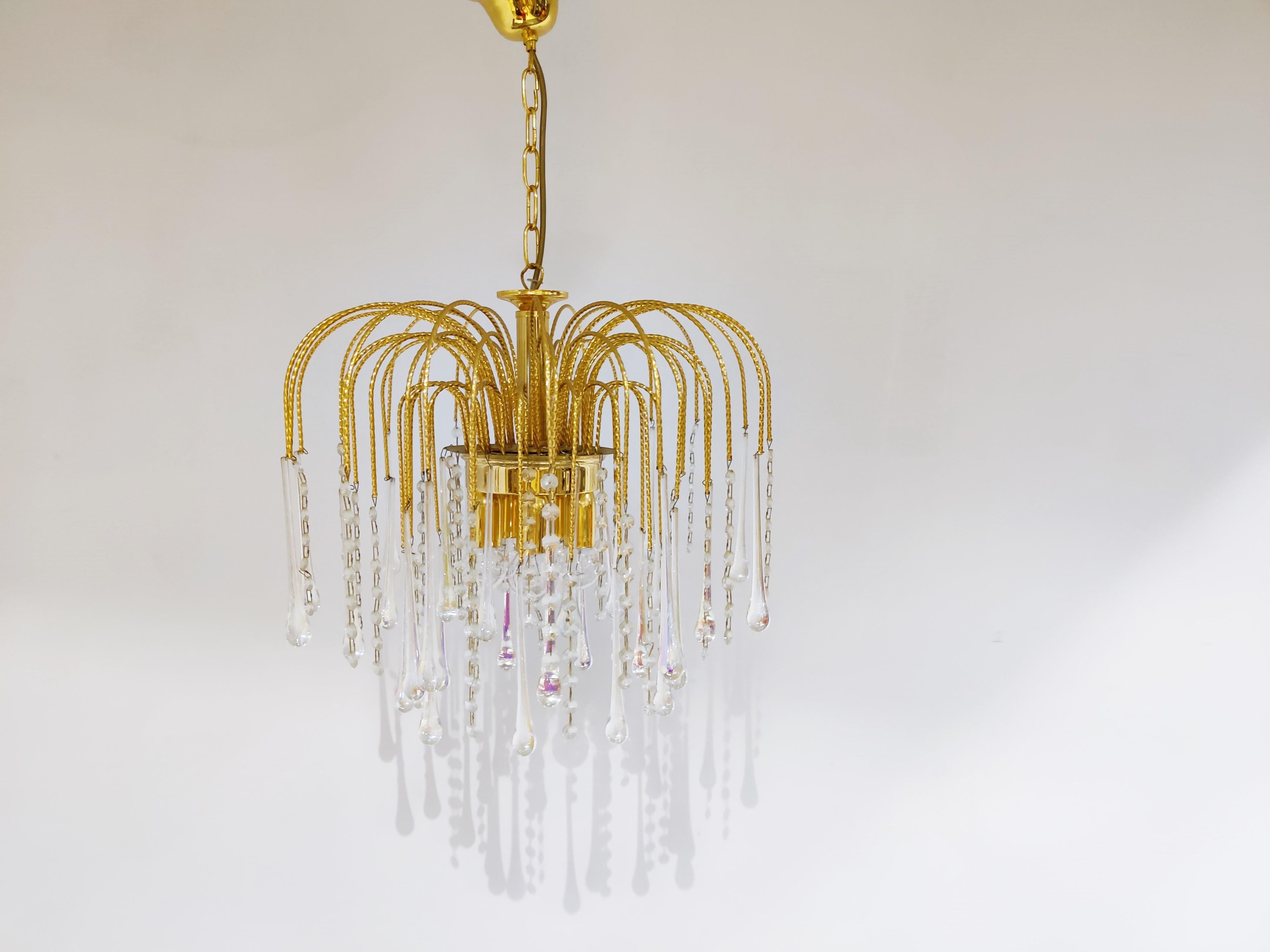 Elegant brass and murano crystal chandelier.

The lamp is decorated with handblown cystal murano teardrop glasses.

The chandelier emits a stunning light.

The lamp is fitted with 6 E27 light sockets.

1970s - Italy

Measures: Height: