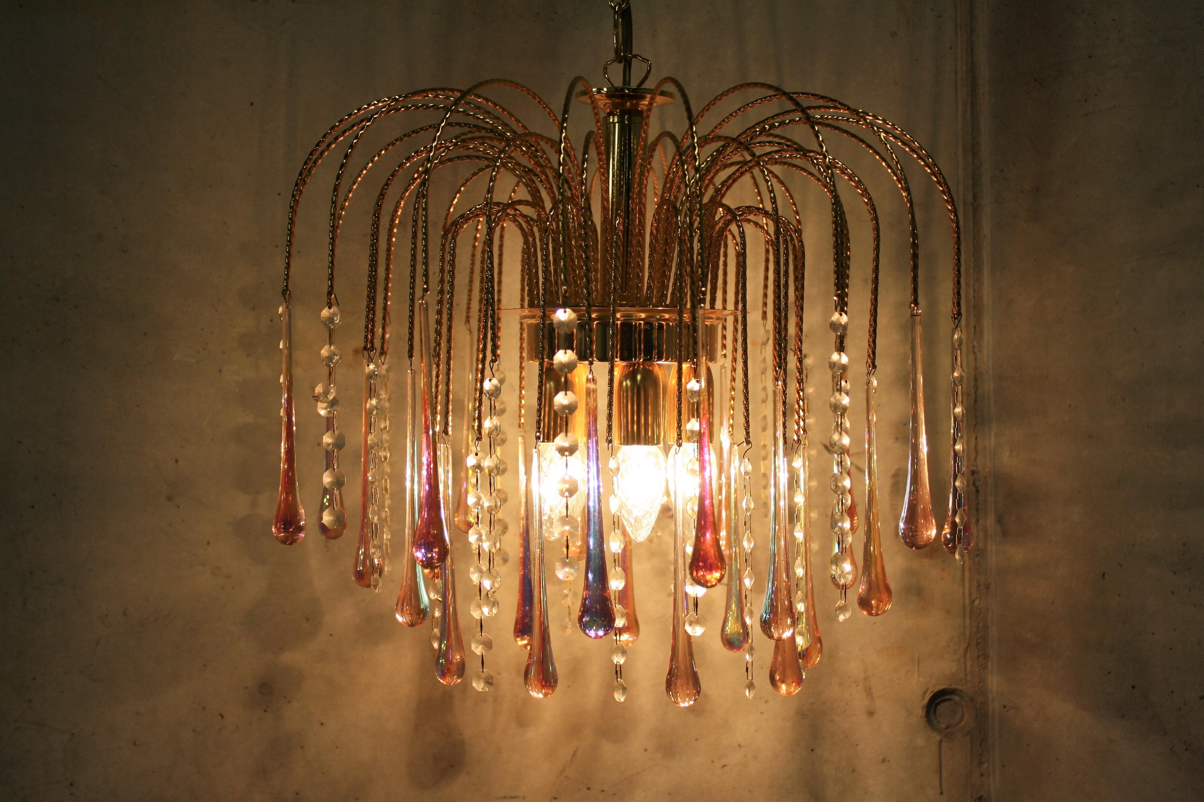 Elegant brass and crystal chandelier.

The lamp is decorated with handblown pink crystal Murano teardrop glasses.

This chandelier emits a warm light.

The lamp is fitted with five E14 light sockets.

It comes with its original chain and