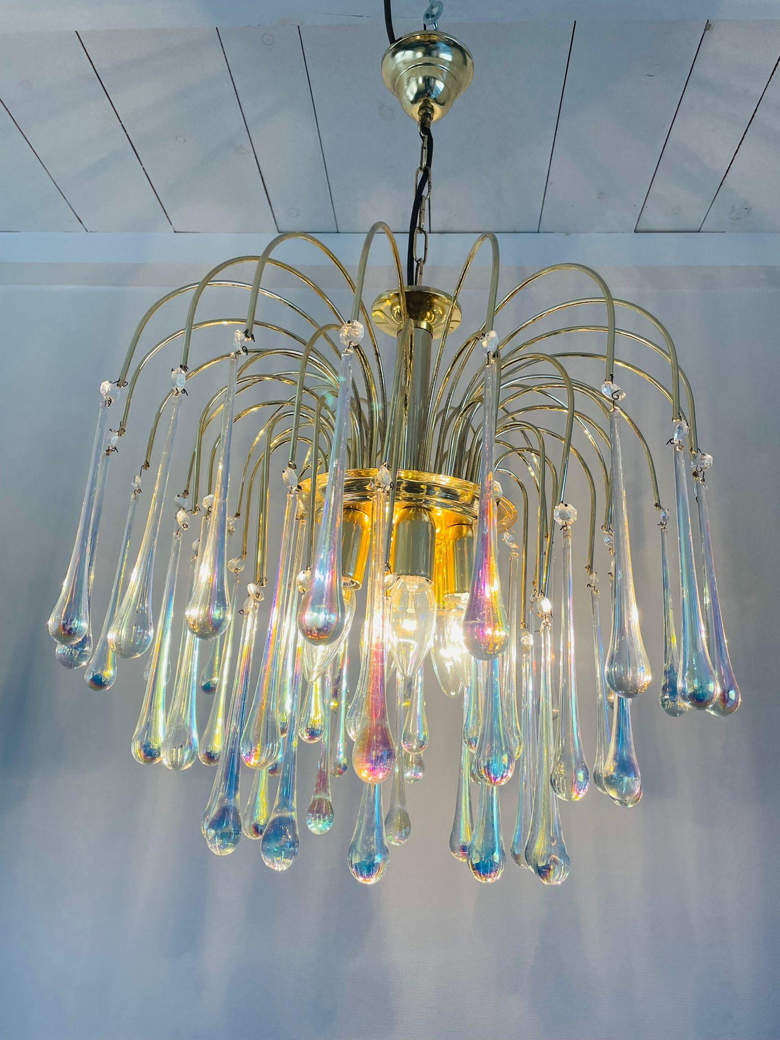 Elegant brass and murano crystal chandelier.

The lamp is decorated with handblown cystal murano teardrop glasses.

The chandelier emits a stunning light.

The lamp is fitted with 6 E27 light sockets.

1970s - Italy

Height: