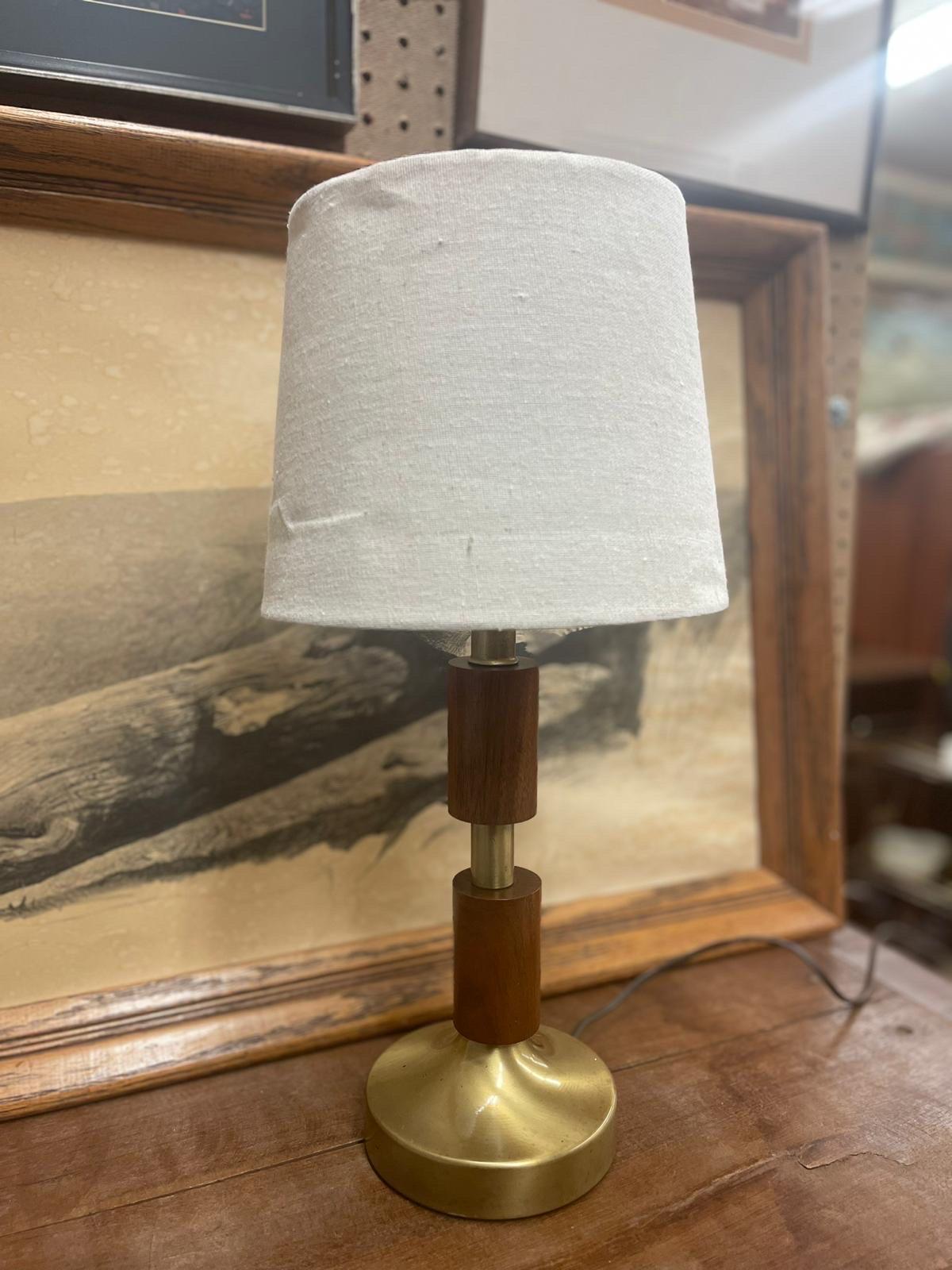 Beautiful Vintage Table Lamp with Walnut Toned Wood Accents and Brass Tone Base. Light Bulb not Included. Oatmeal Toned Lamp Shade Included . Vintage Condition Consistent with Age as Pictured.

Dimensions. 12 Diameter; 17 H
