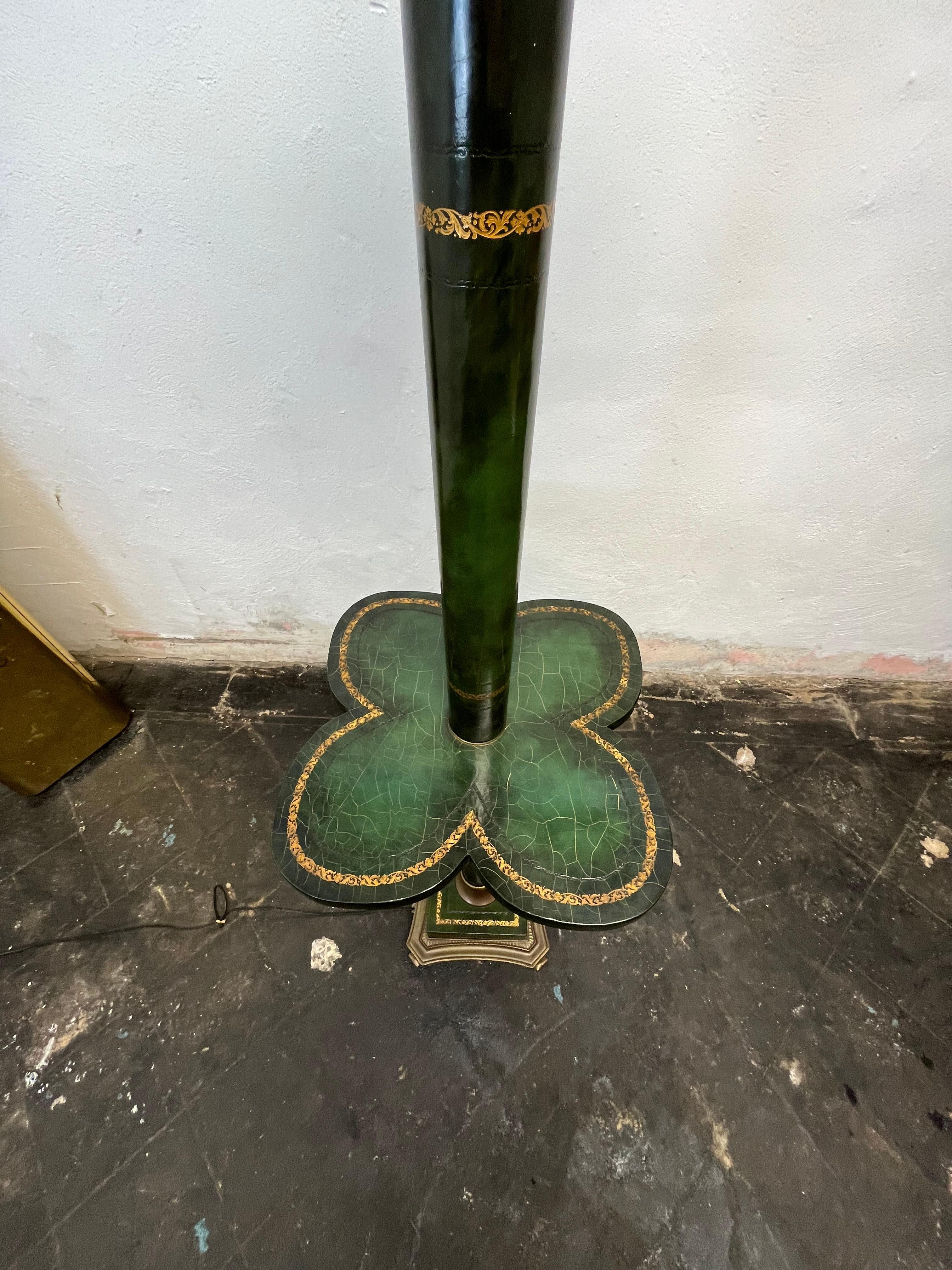 Beautiful leather wrapped torchiere with table top surface. Hunter green leather with crazing along with gold embossed tooling.   Brass base with great deep filigree and shell motif and brass top. Lace detail in frosted shade. 