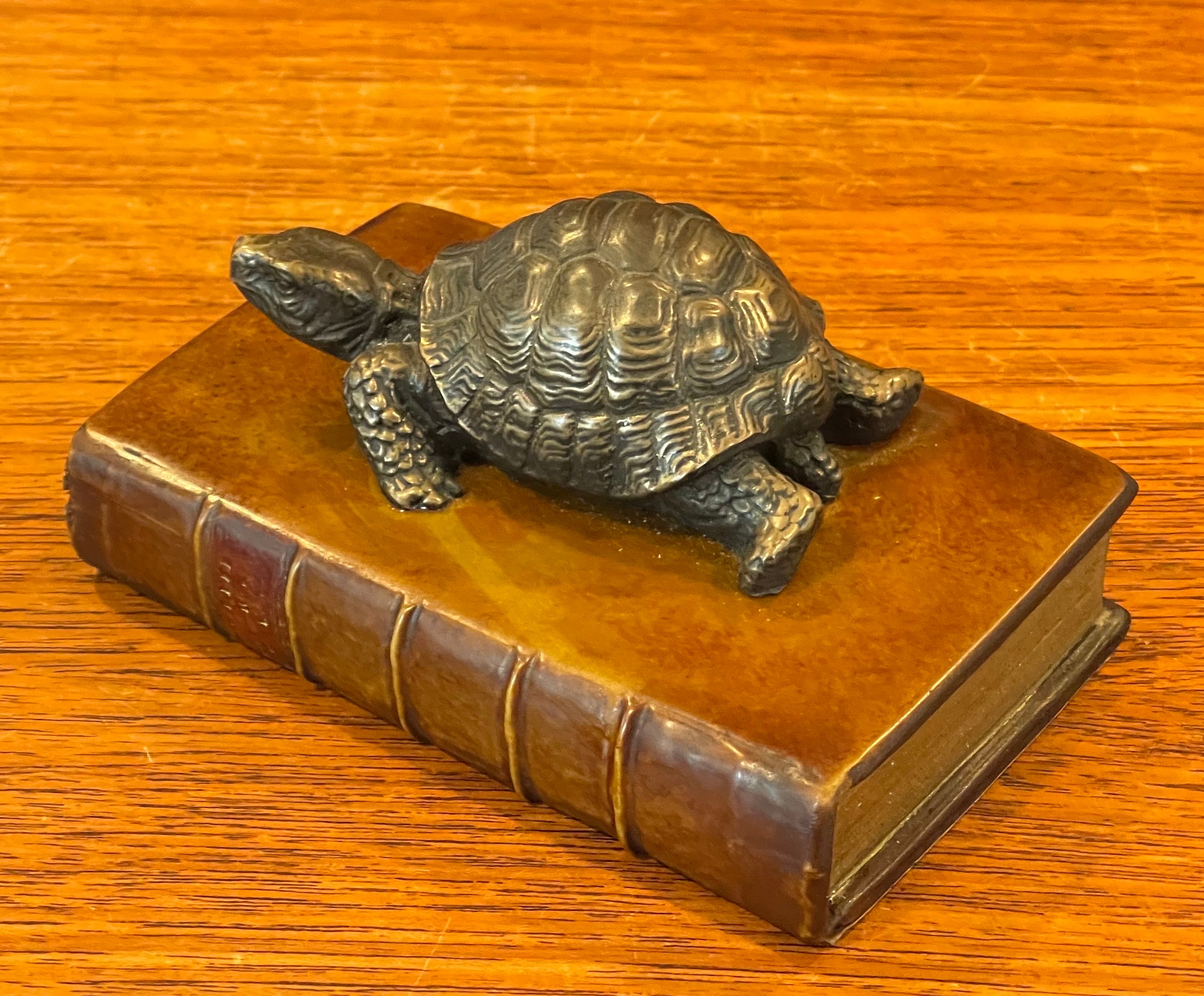Unique vintage brass turtle on faux book paperweight, circa 1970s. The piece is in very good vintage condition and measures 5.25