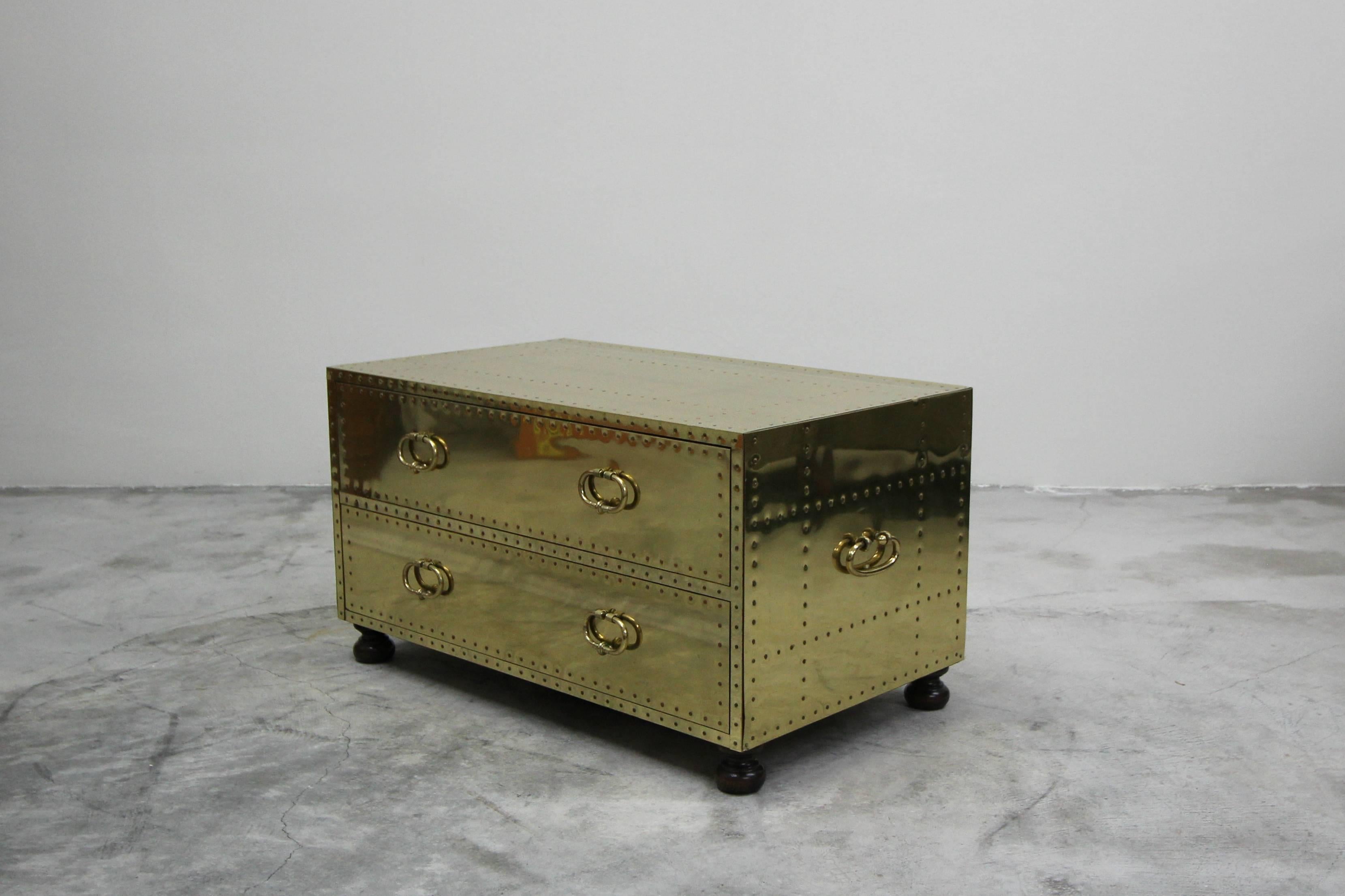 Beautiful brass two drawer chest made in Spain by Sarreid. Could be used as a coffee table, bench or even a bedside table. Sits on four bun feet.

Almost mint condition, with little to no patina and minimal surface scratches.
