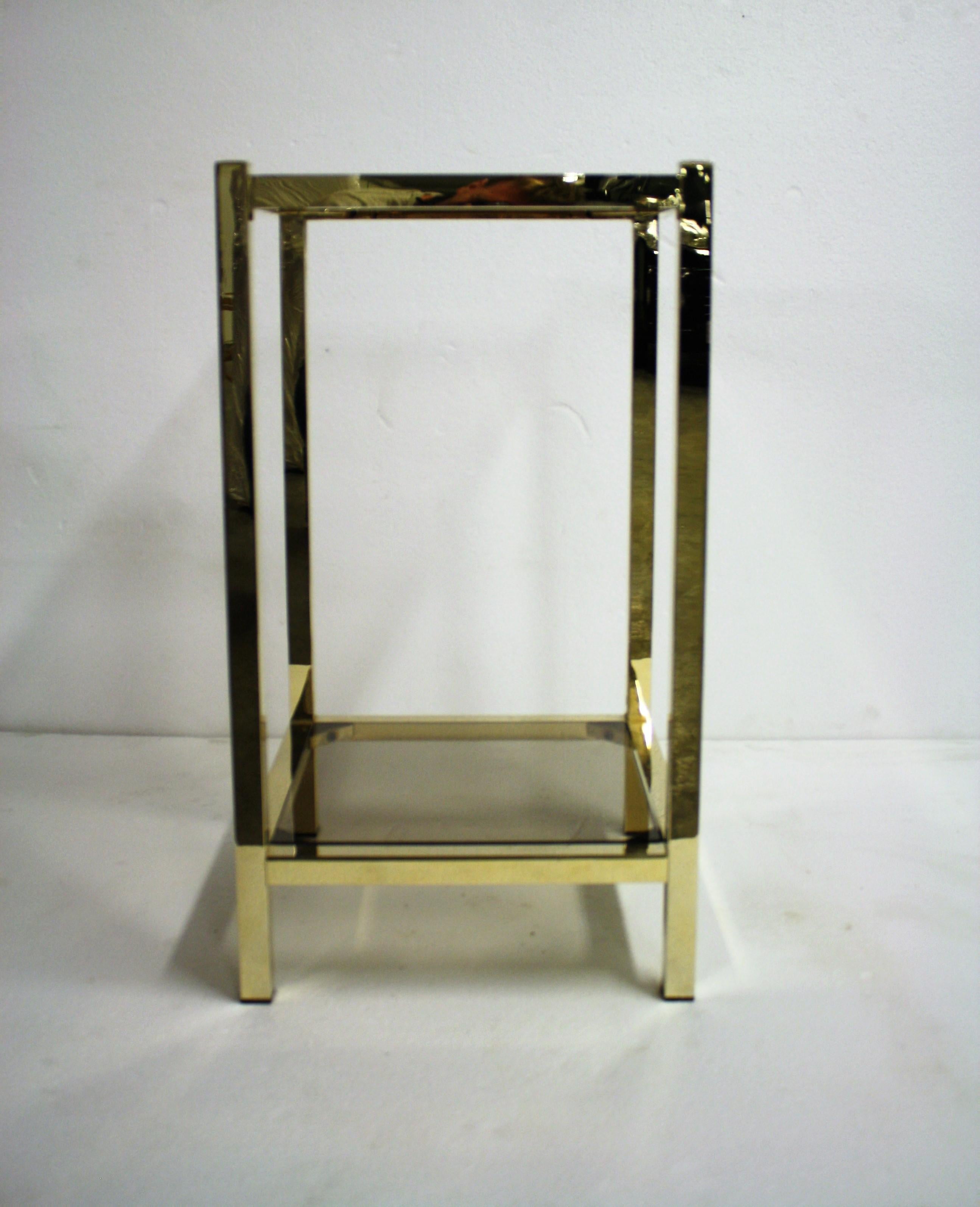 Midcentury brass two-tier display table with smoked glass.

The tables has been polished back to it's original shiny golden color.

Good condition, original undamaged glass.

Ideal to use as a display table or side table.

1970s,