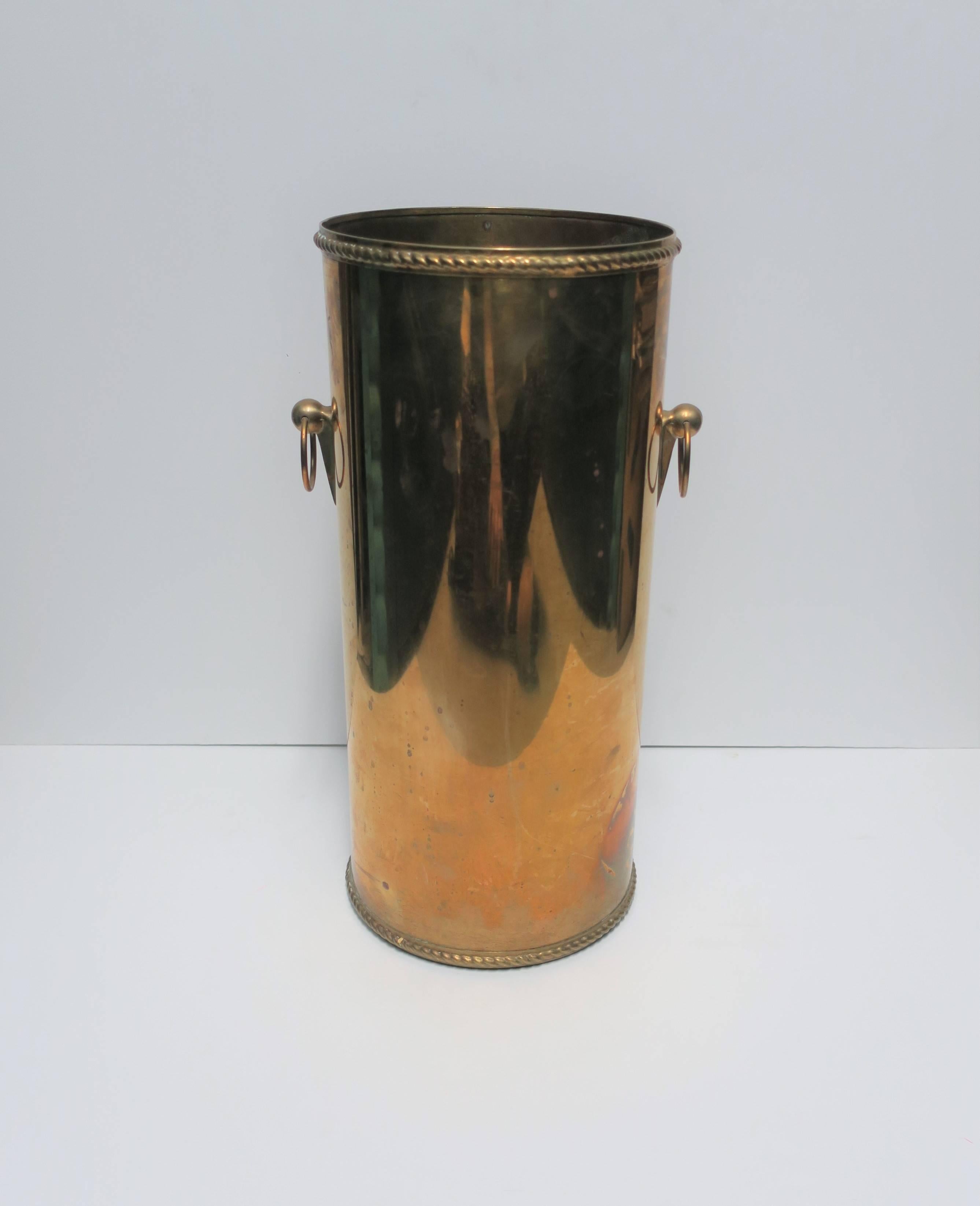 Vintage solid brass umbrella stand with decorative rim at top and base, and decorative spikes on sides supporting the ball and loop handles. 

Piece measures: 8.25