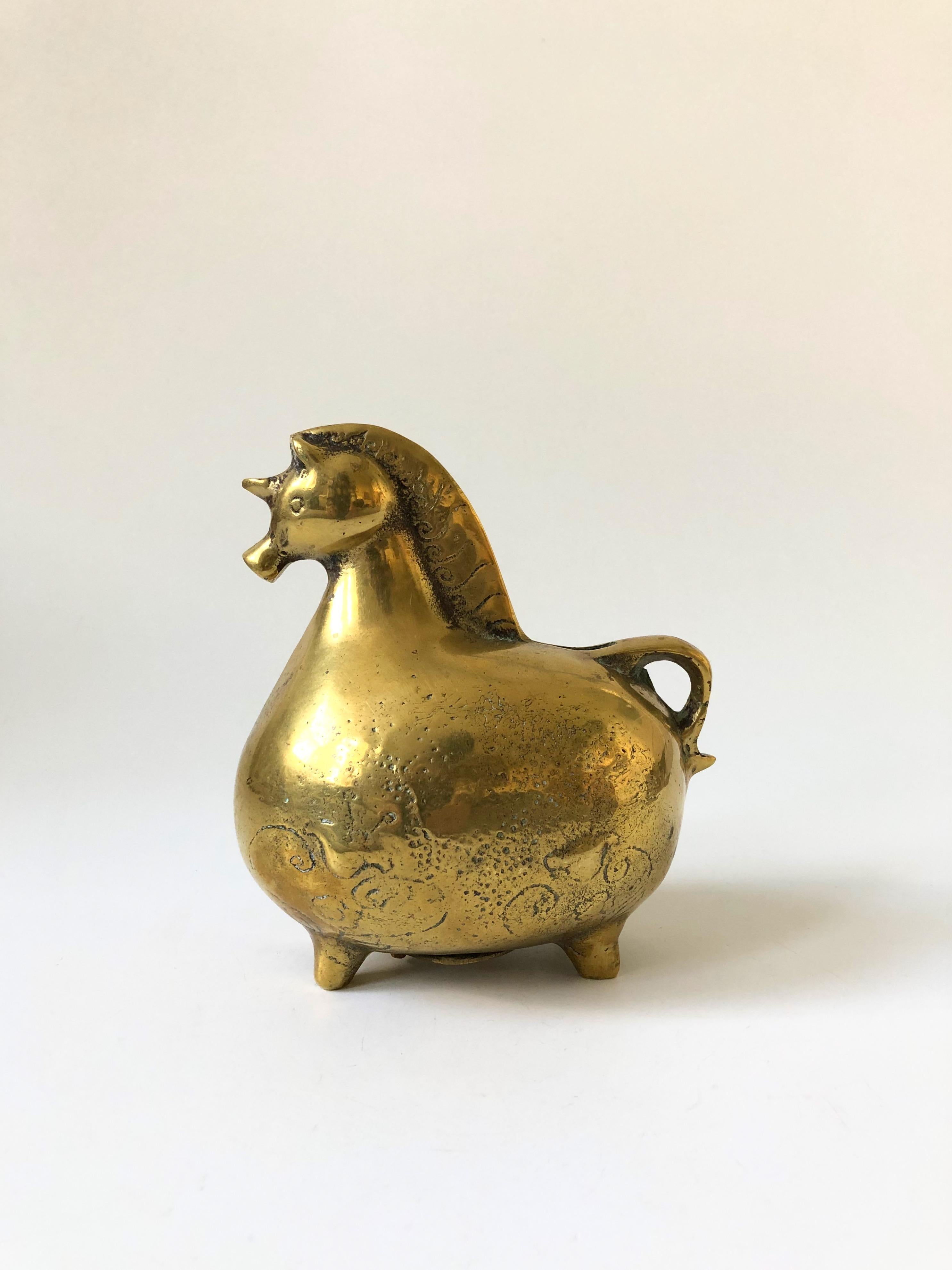 A vintage brass bank in the shape of a unicorn. Adorable rotund shape. A plate on the base unscrews for removing coins.
    